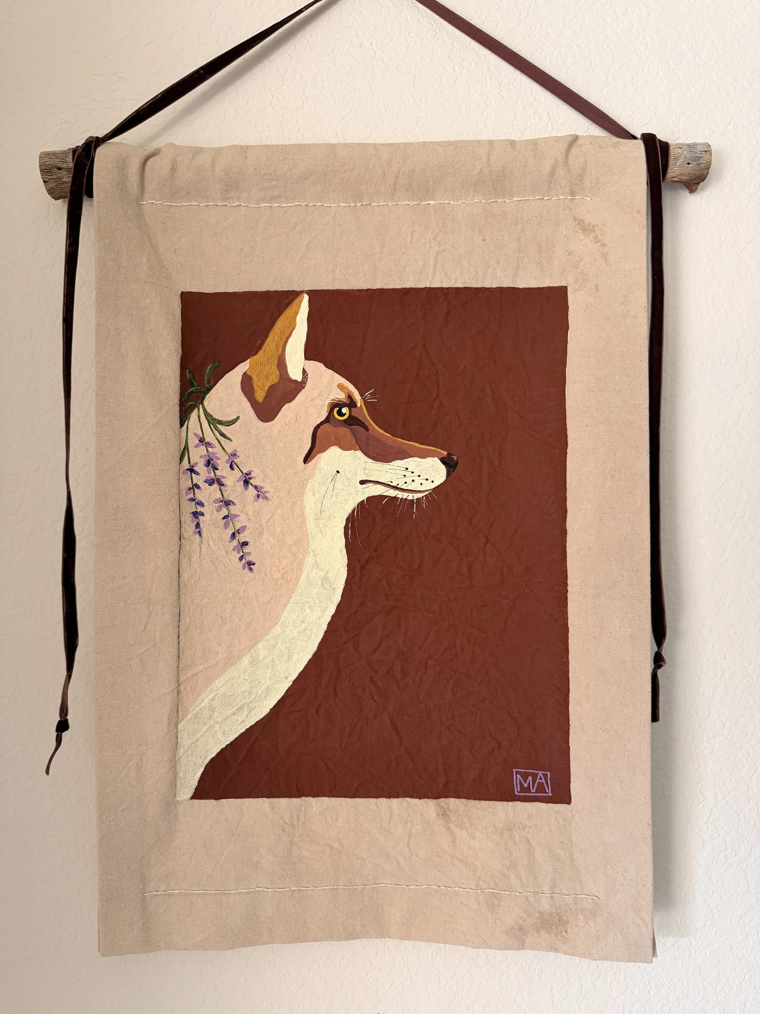 Tapestry featuring a dog with lavender flowers, hanging from a wooden dowel with a leather strap.