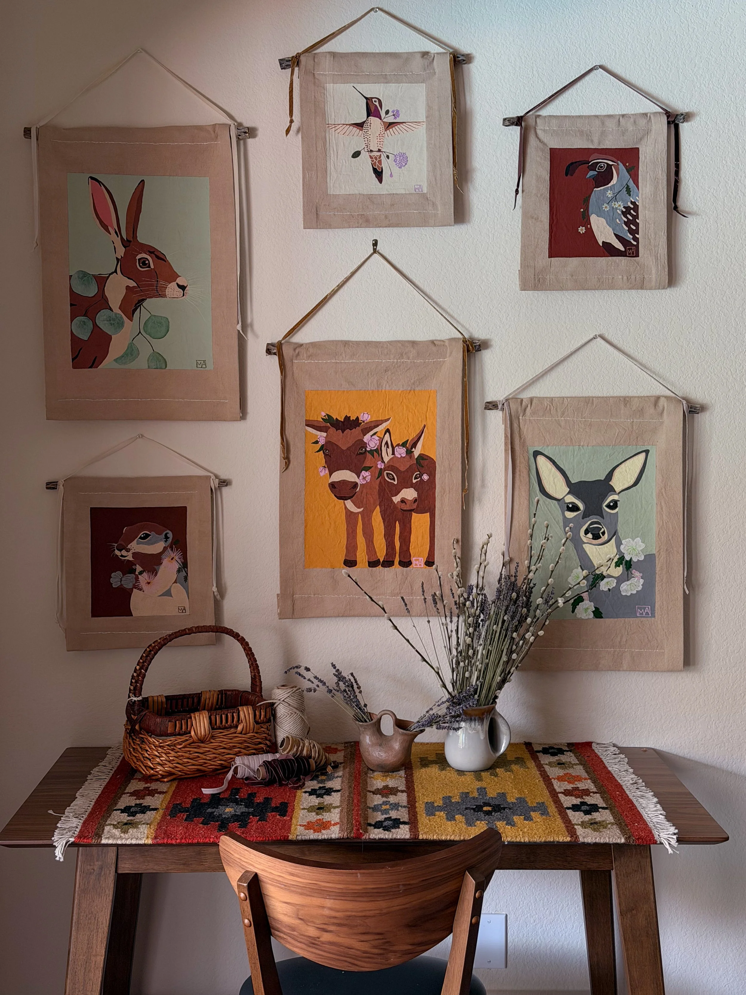 Gallery wall featuring original desert animal paintings and handmade textile wall hangings by Slow Desert Studio in Tucson, Arizona.