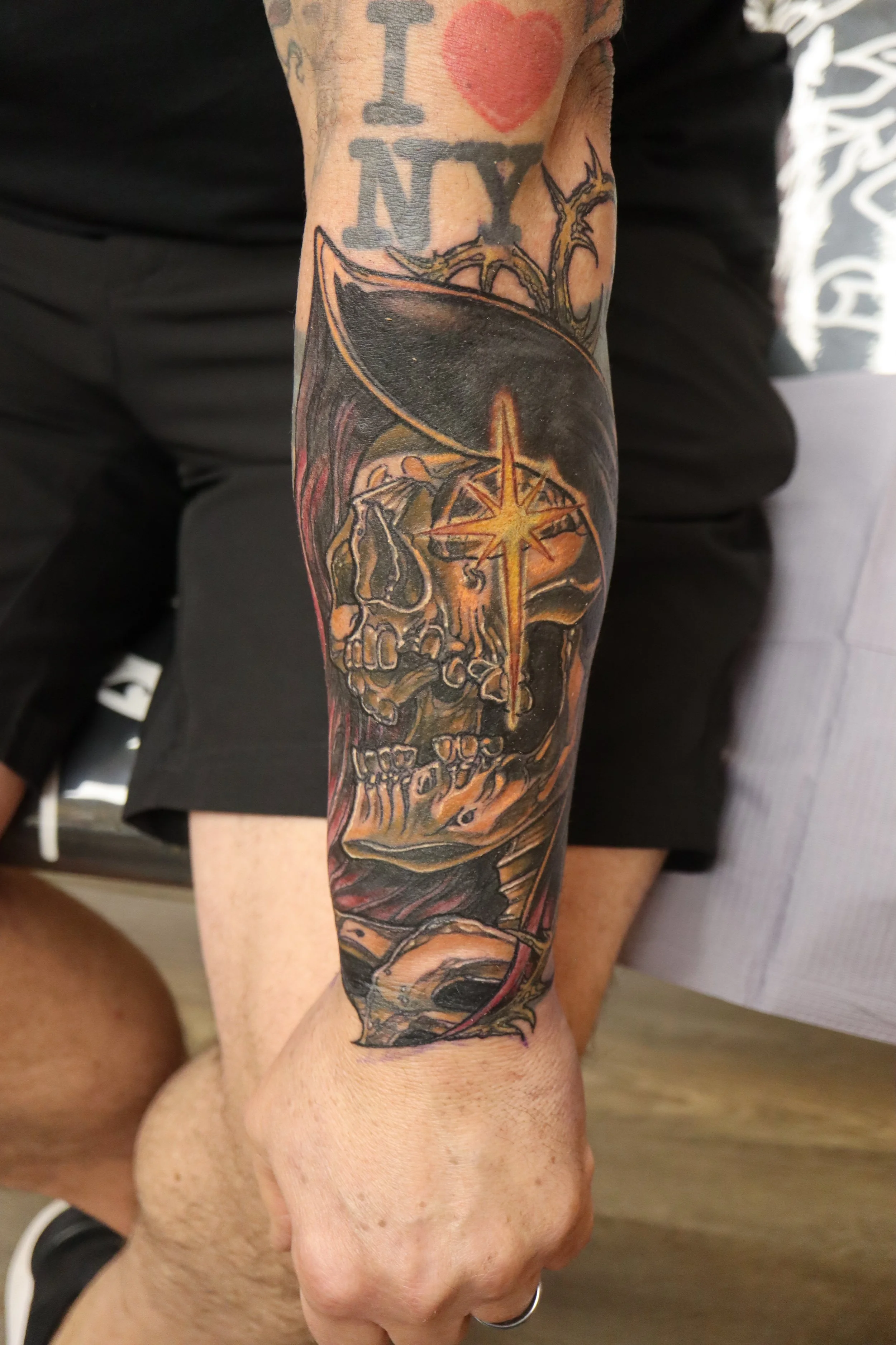 A tattoo sleeve featuring a skull, a star, and various intricate designs on a person's arm. Neo traditional tattoo. Cover up tattoo.