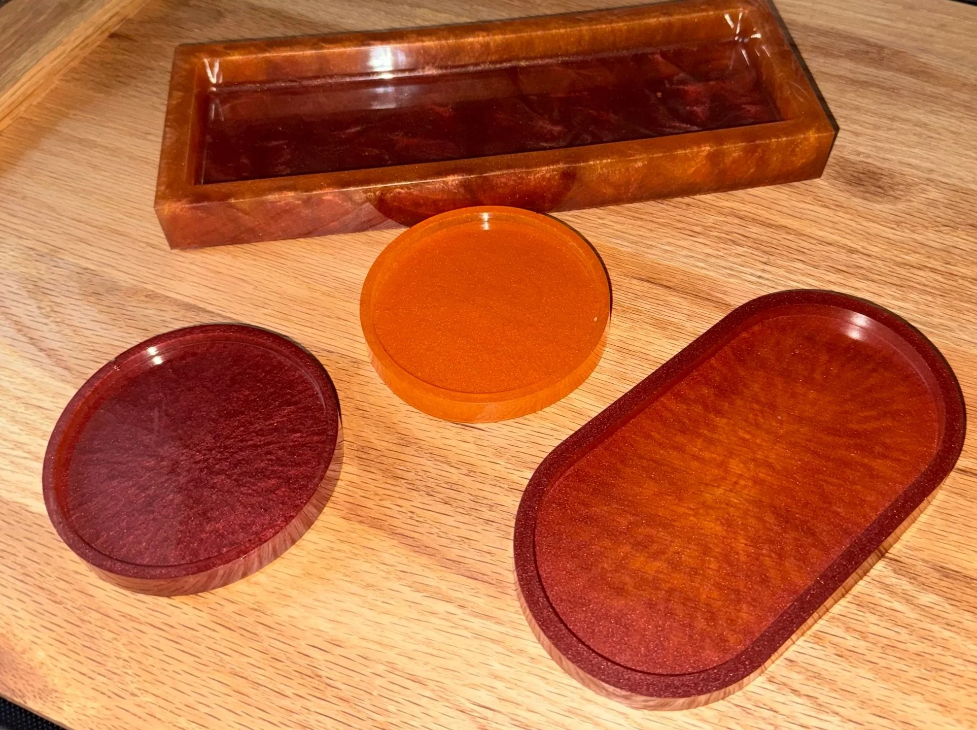 Set of game pieces including circular pieces of various colors and a rectangular wooden tray for holding the pieces, all placed on a wooden surface.