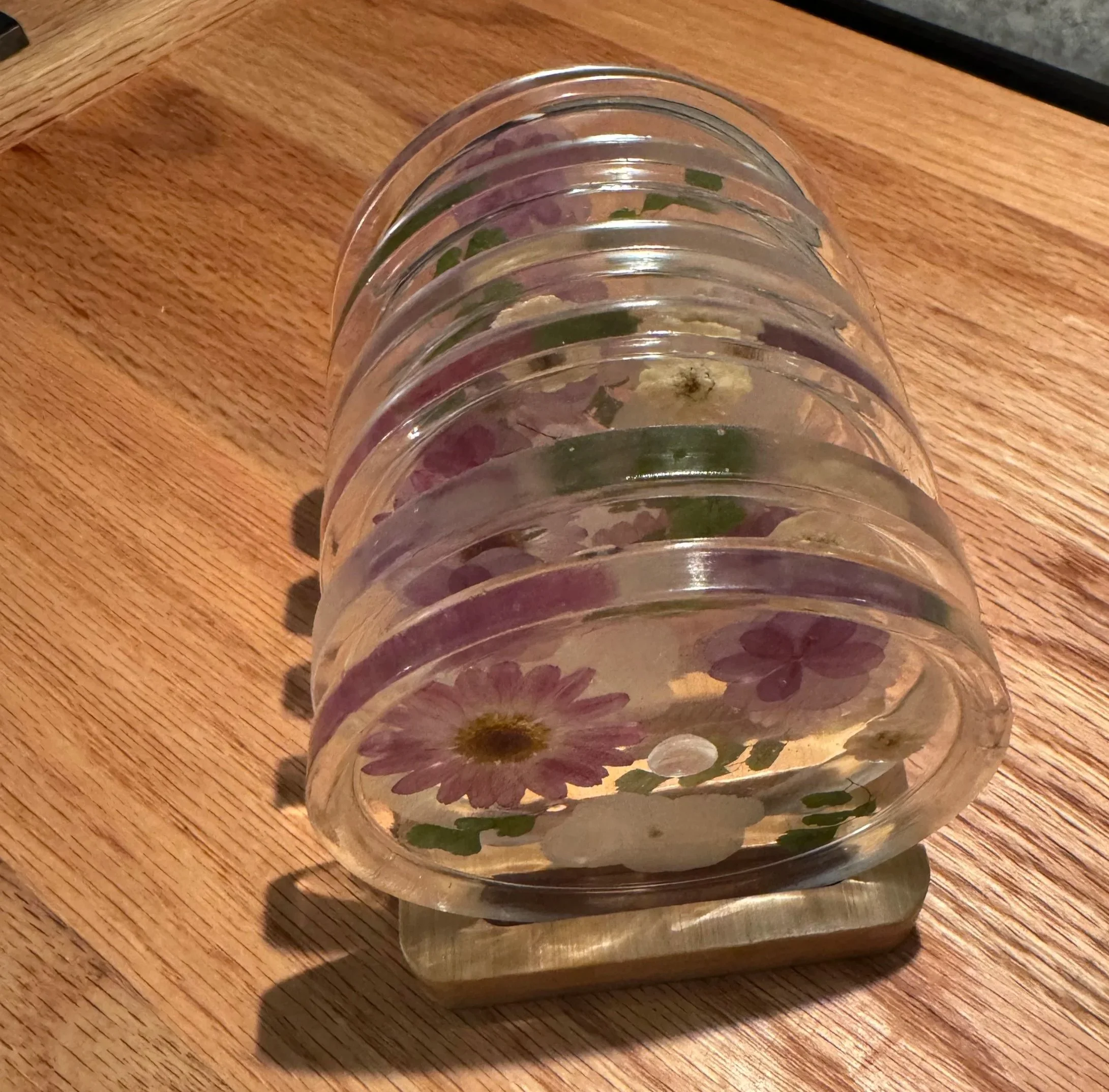 A series of clear glass shot glasses stacked on top of each other, placed on a wooden surface.