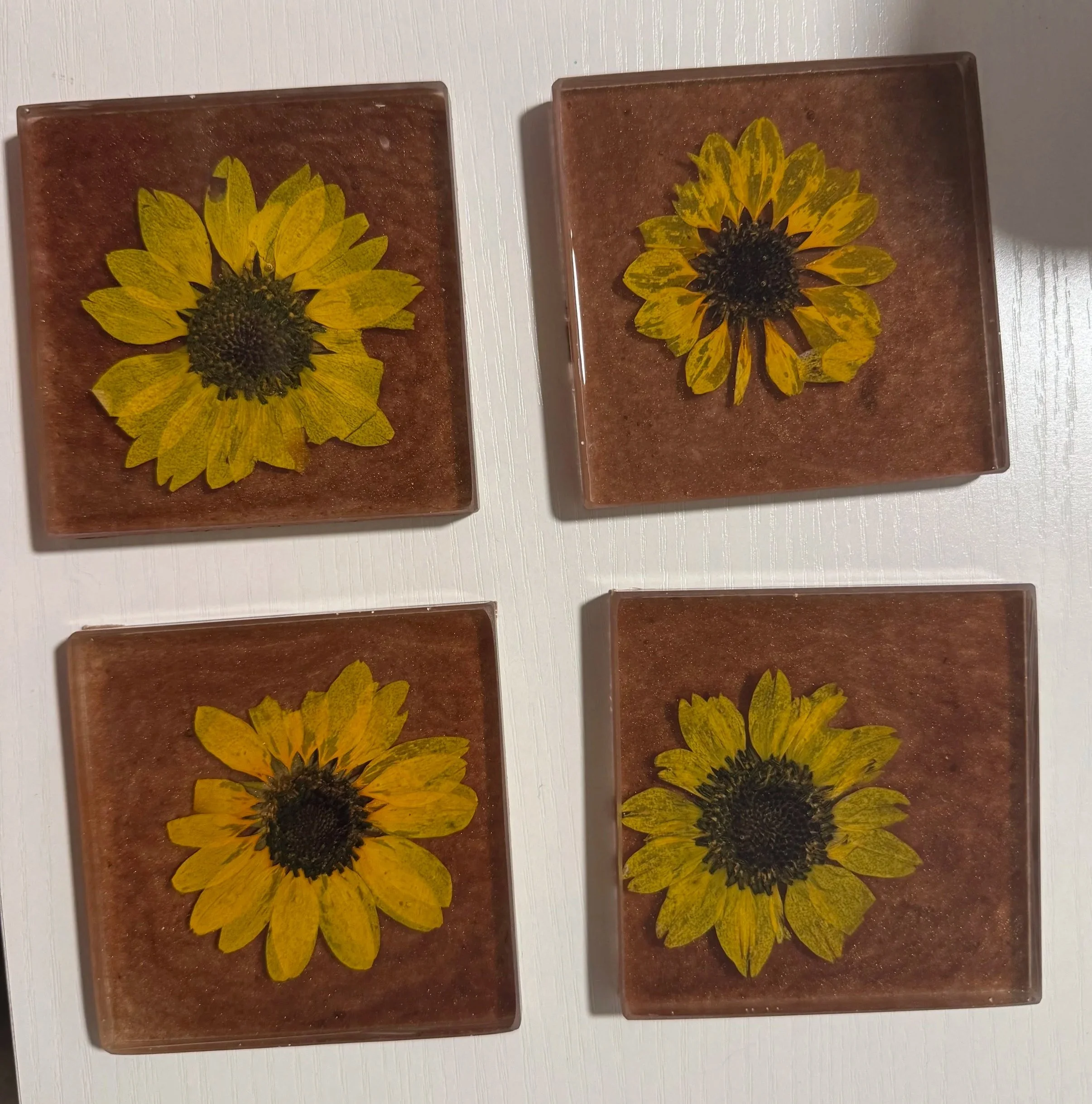 Two decorative panels with sunflower images on a white surface.