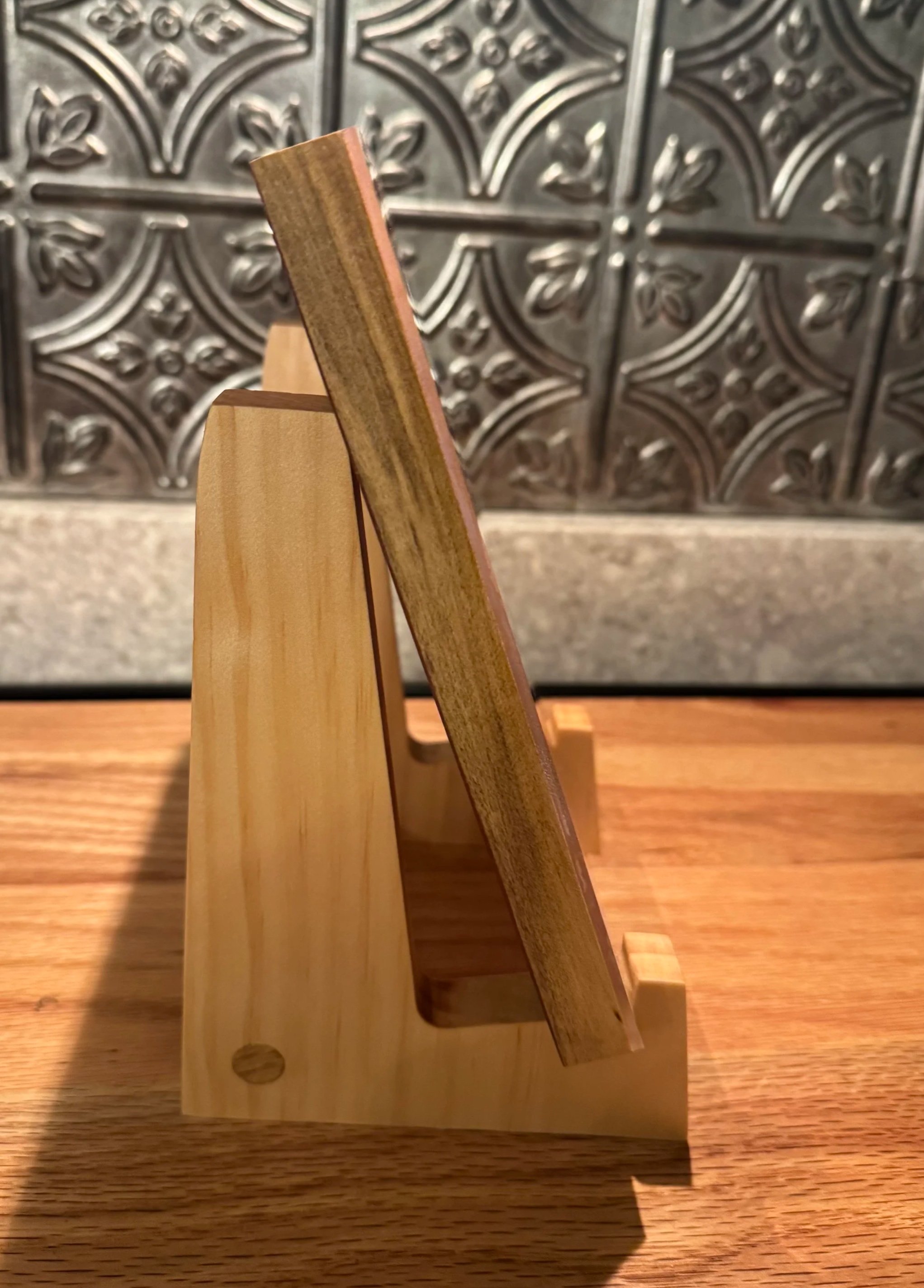 A small wooden easel for holding photo frames, cutting boards, charcuterie boards, or cookbooks.  