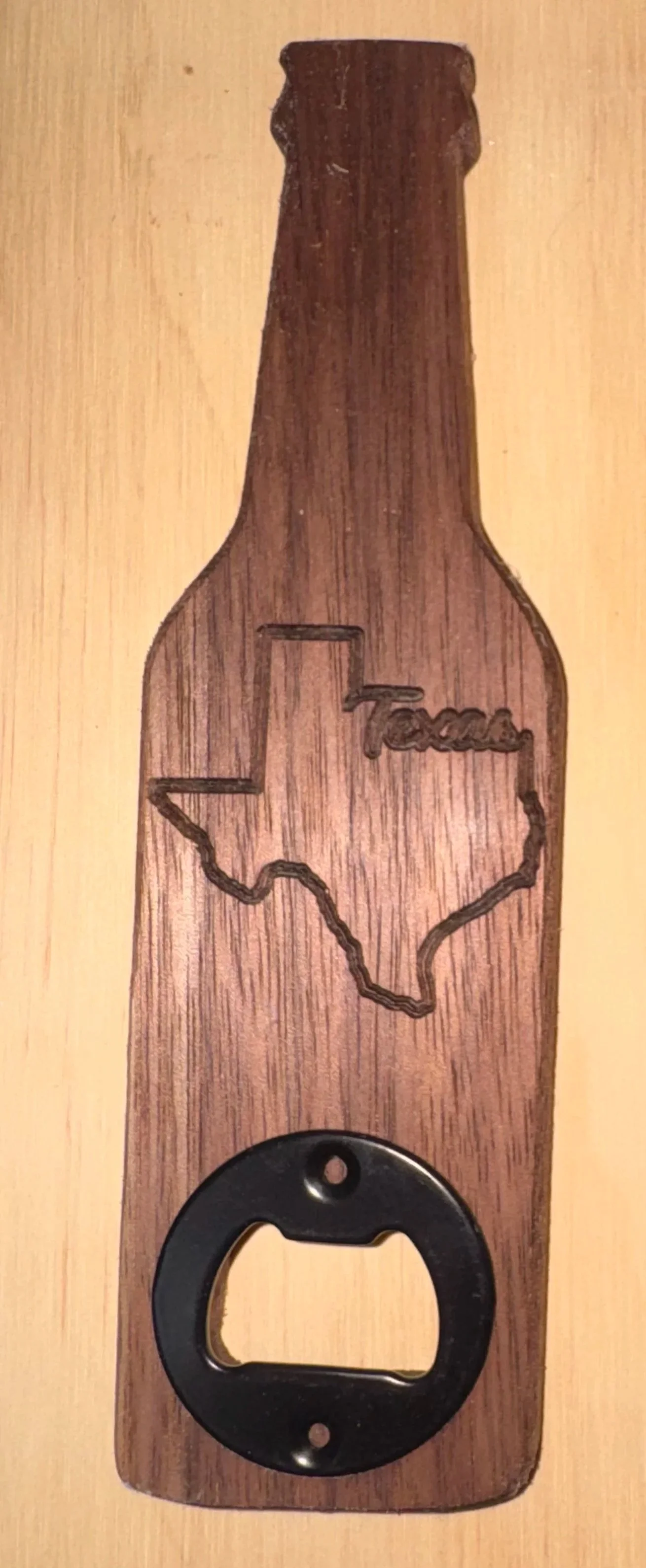 Wooden bottle opener with a Texas outline and the word "Texas" engraved inside.