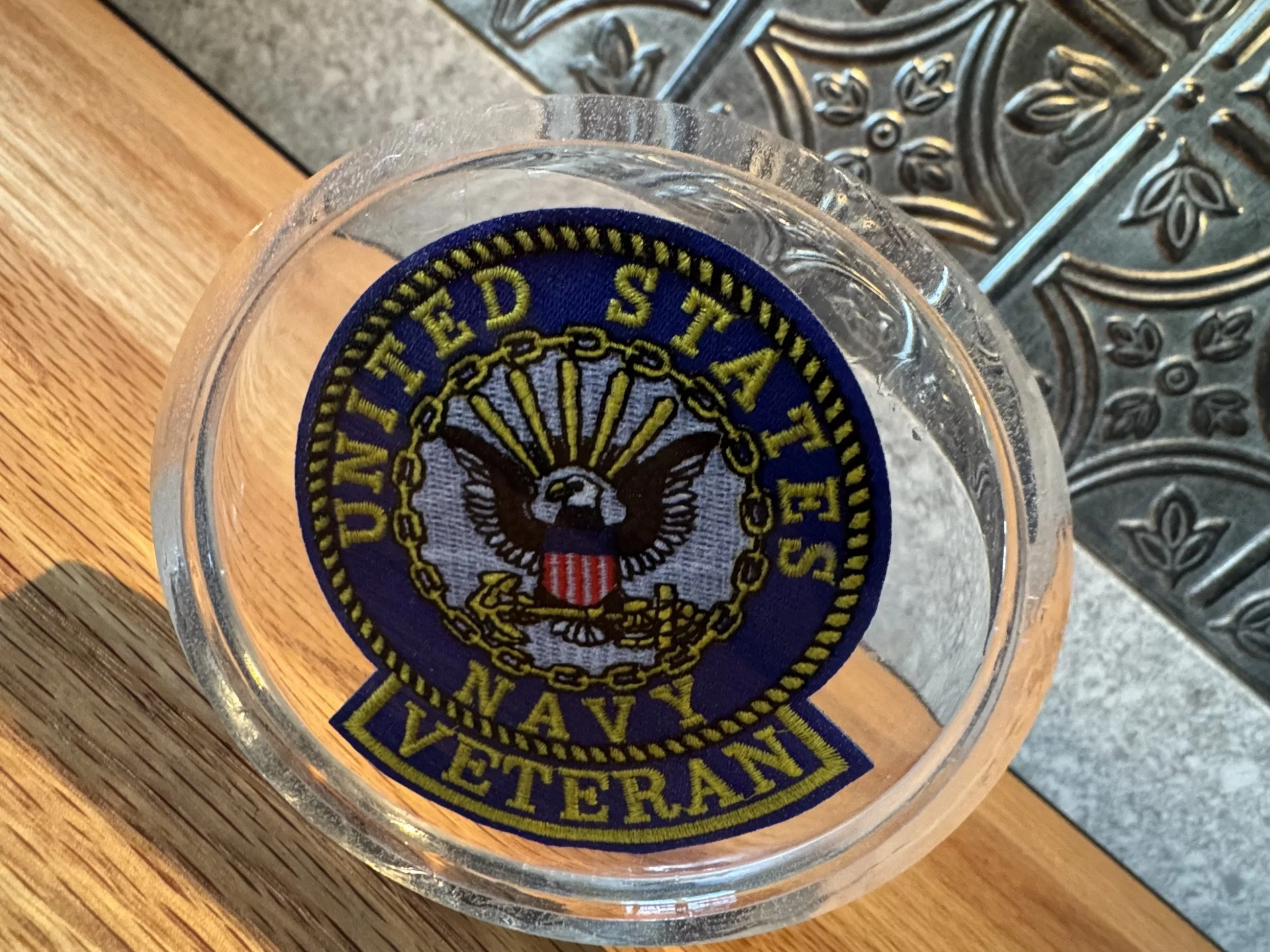 Close-up of a glass with a badge or patch on it that has the logo of a Southwest Airlines Pilot with an eagle emblem and gold lettering.