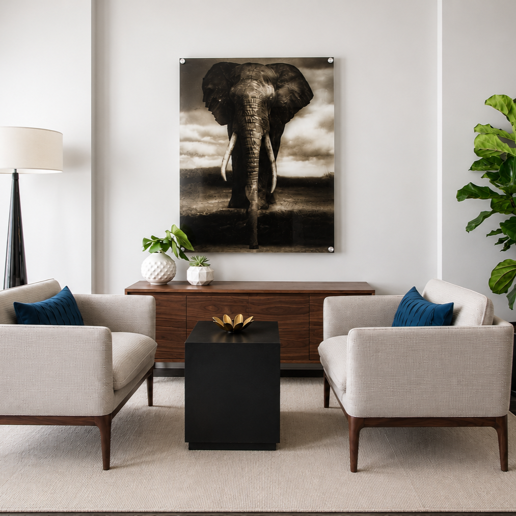 Living room with two beige armchairs, a black coffee table, a wooden sideboard, a large black and white elephant art piece, two white vases with green plants, a tall white lamp, and a large green potted plant.