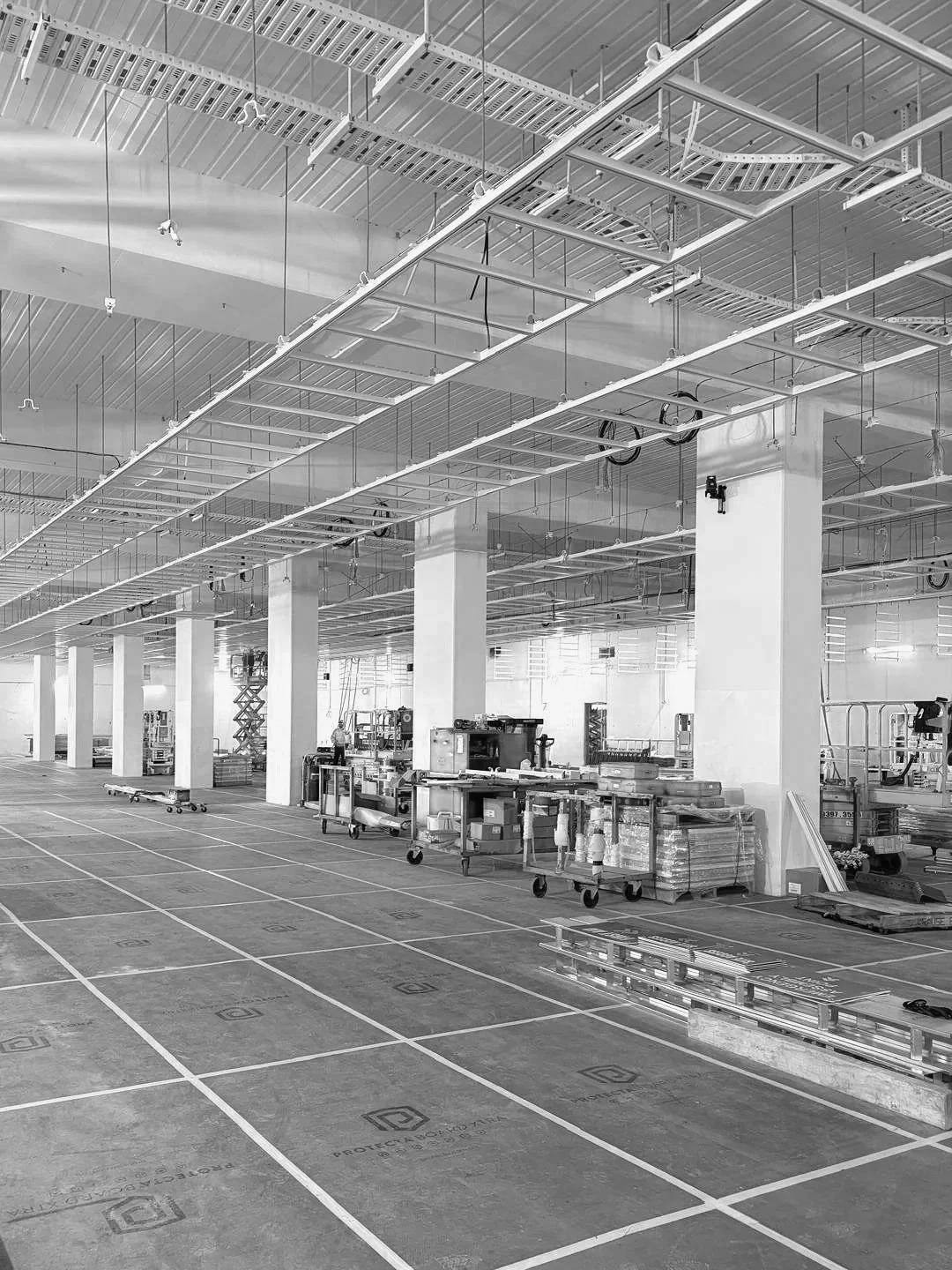 Data Centre construction, Melbourne. Infrastructure, including metal framing and wiring, and a floor marked with grid lines for layout.