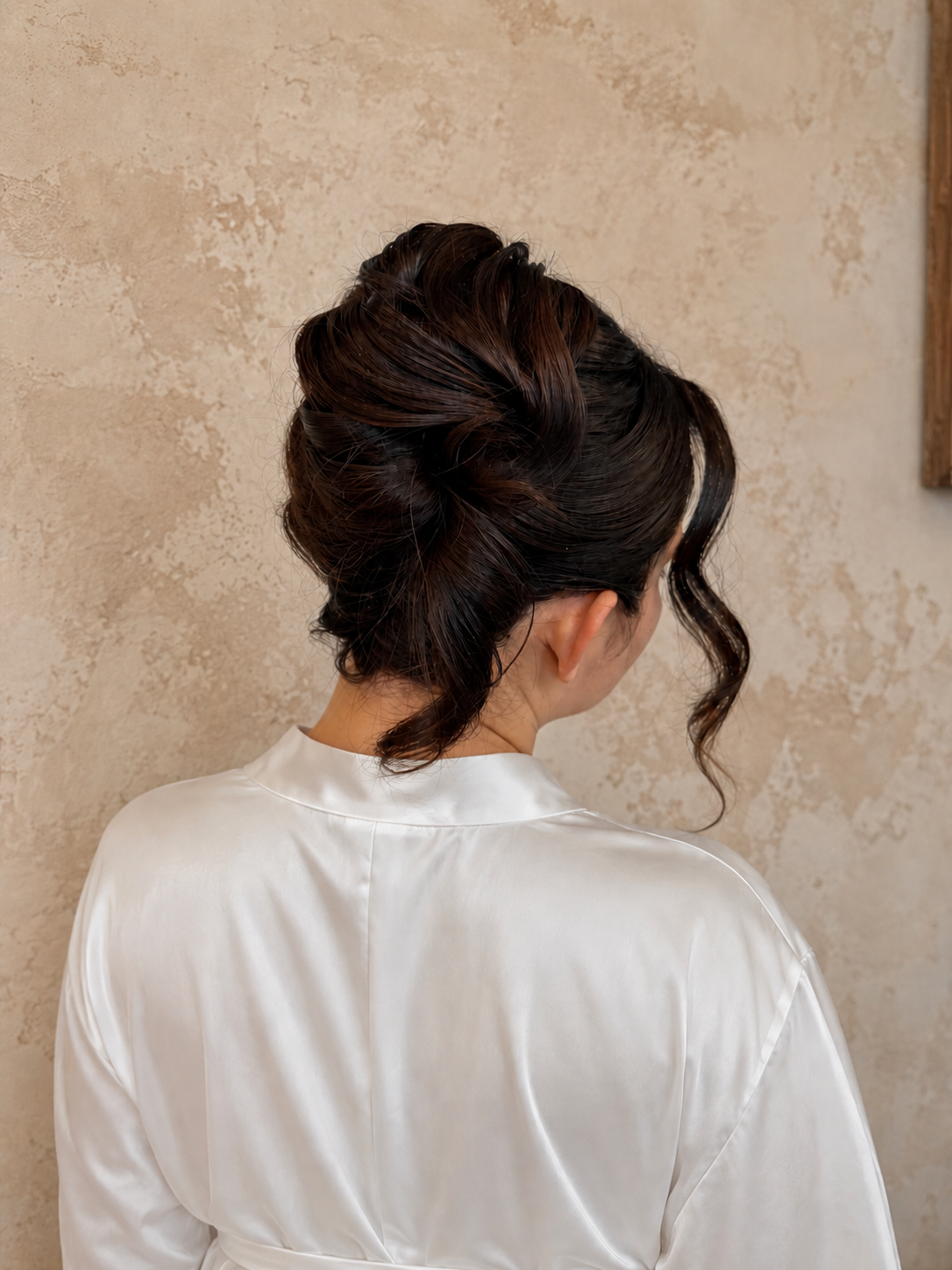 a bride in  a white robe with an elegant French twist updo 