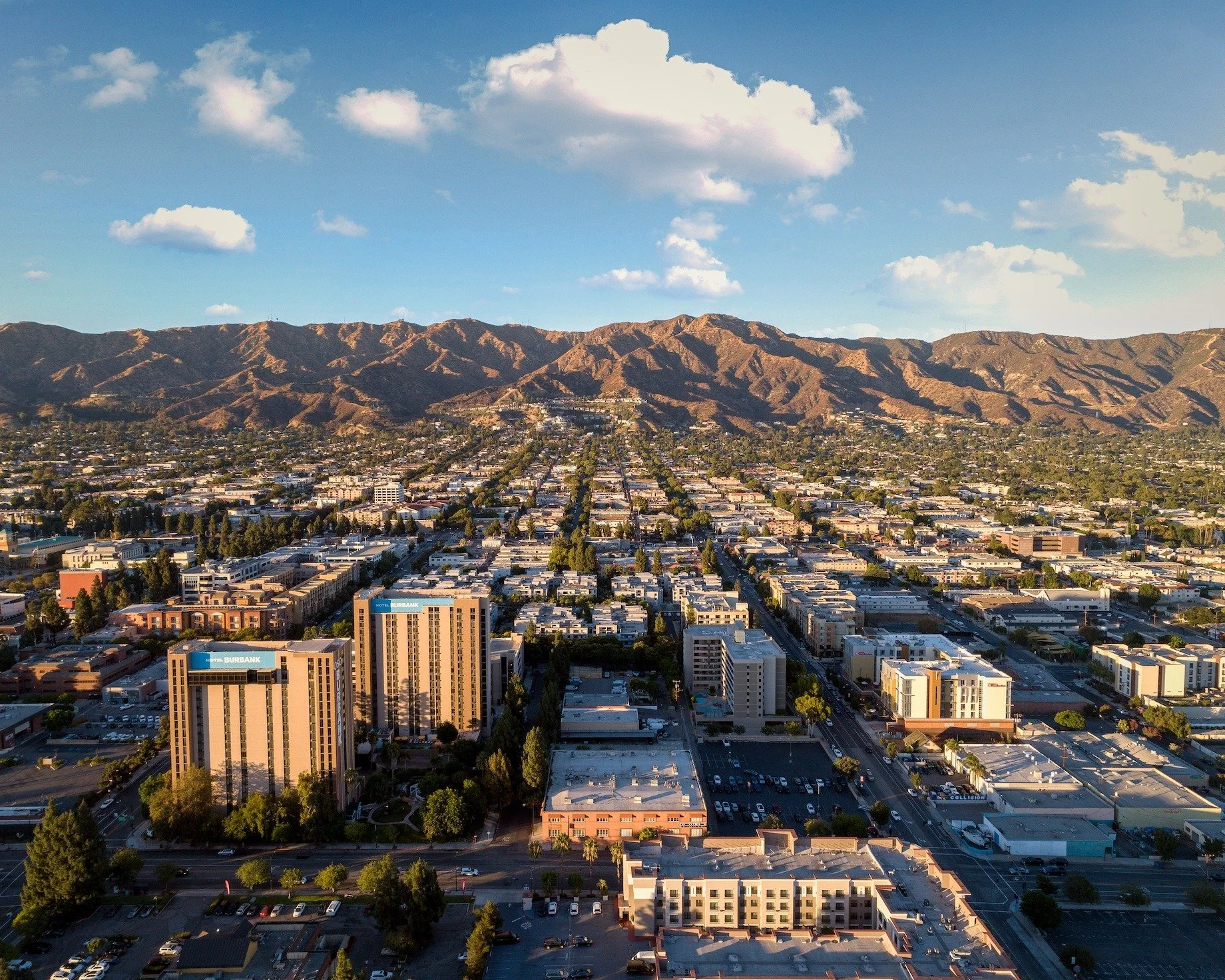 Aerial view of Downtown Burbank, California with surrounding neighborhoods and mountains.