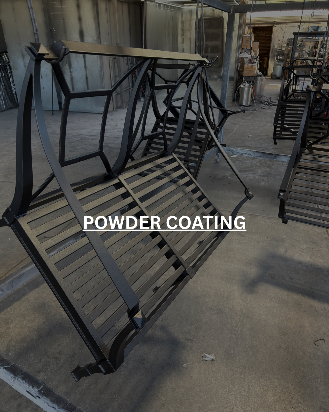 Black metal bench with a powder-coated finish in a workshop setting.