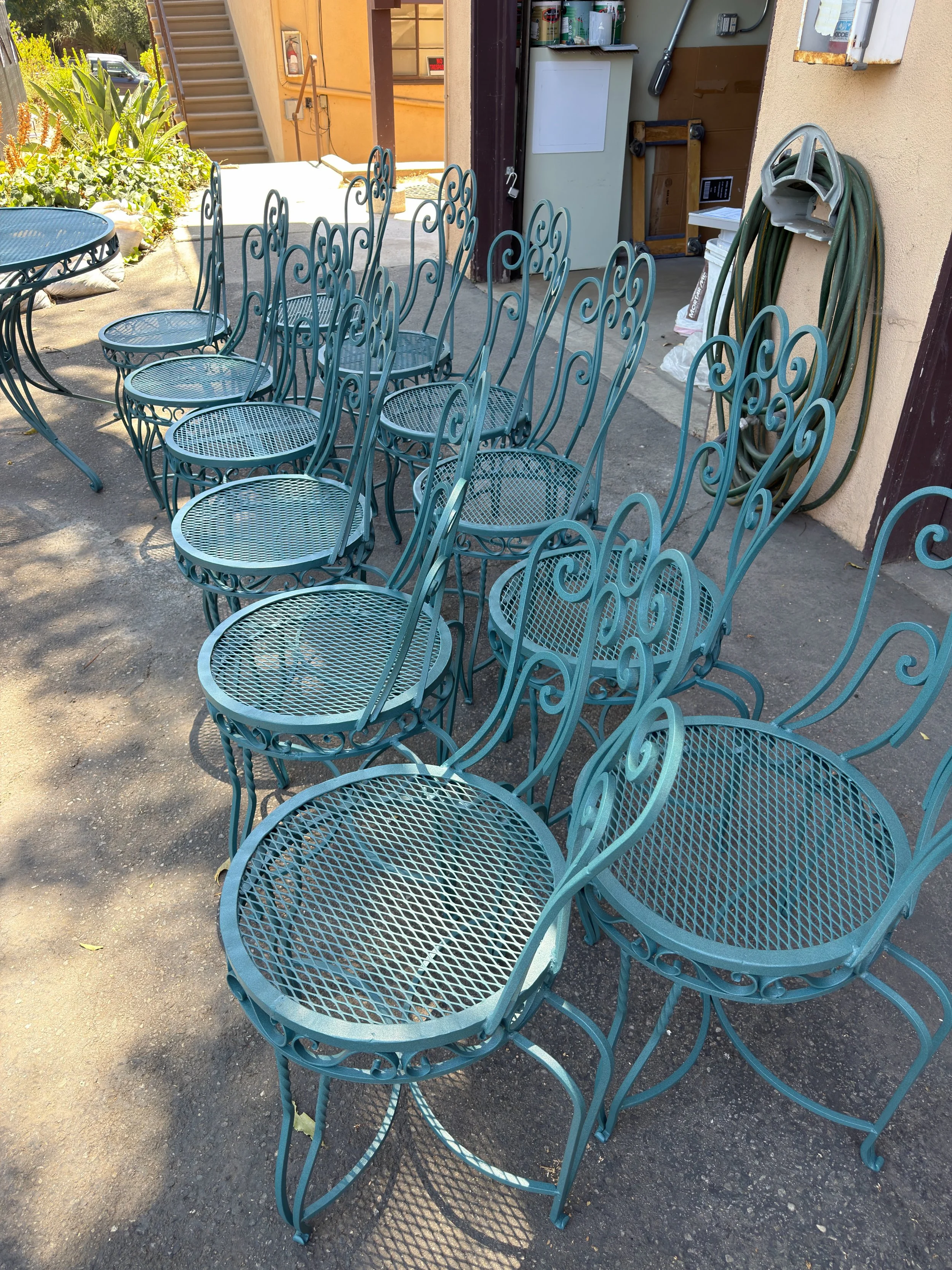 A batch of metal patio chairs freshly powder coated during the restoration process.