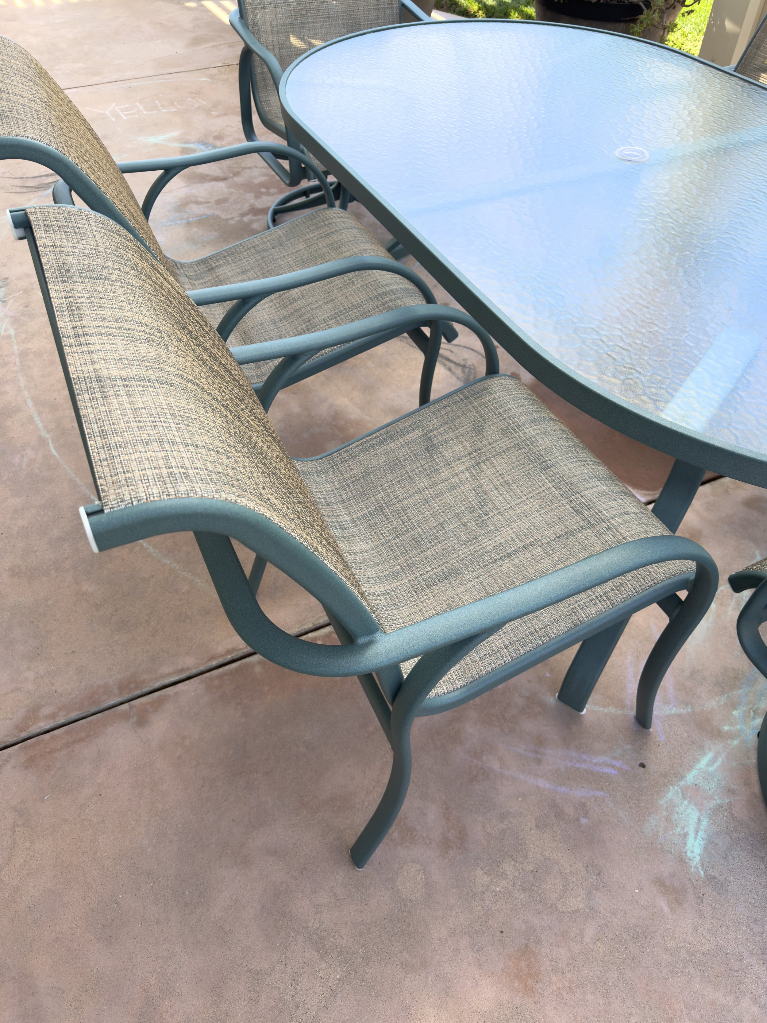 Outdoor dining chairs with professionally replaced sling fabric and restored metal frames