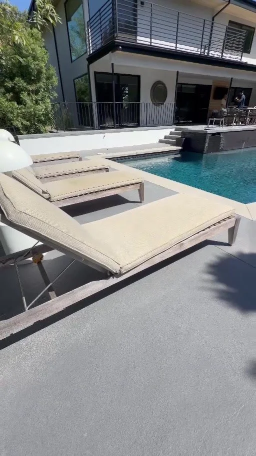 Weathered teak chaise lounges before restoration beside a backyard pool