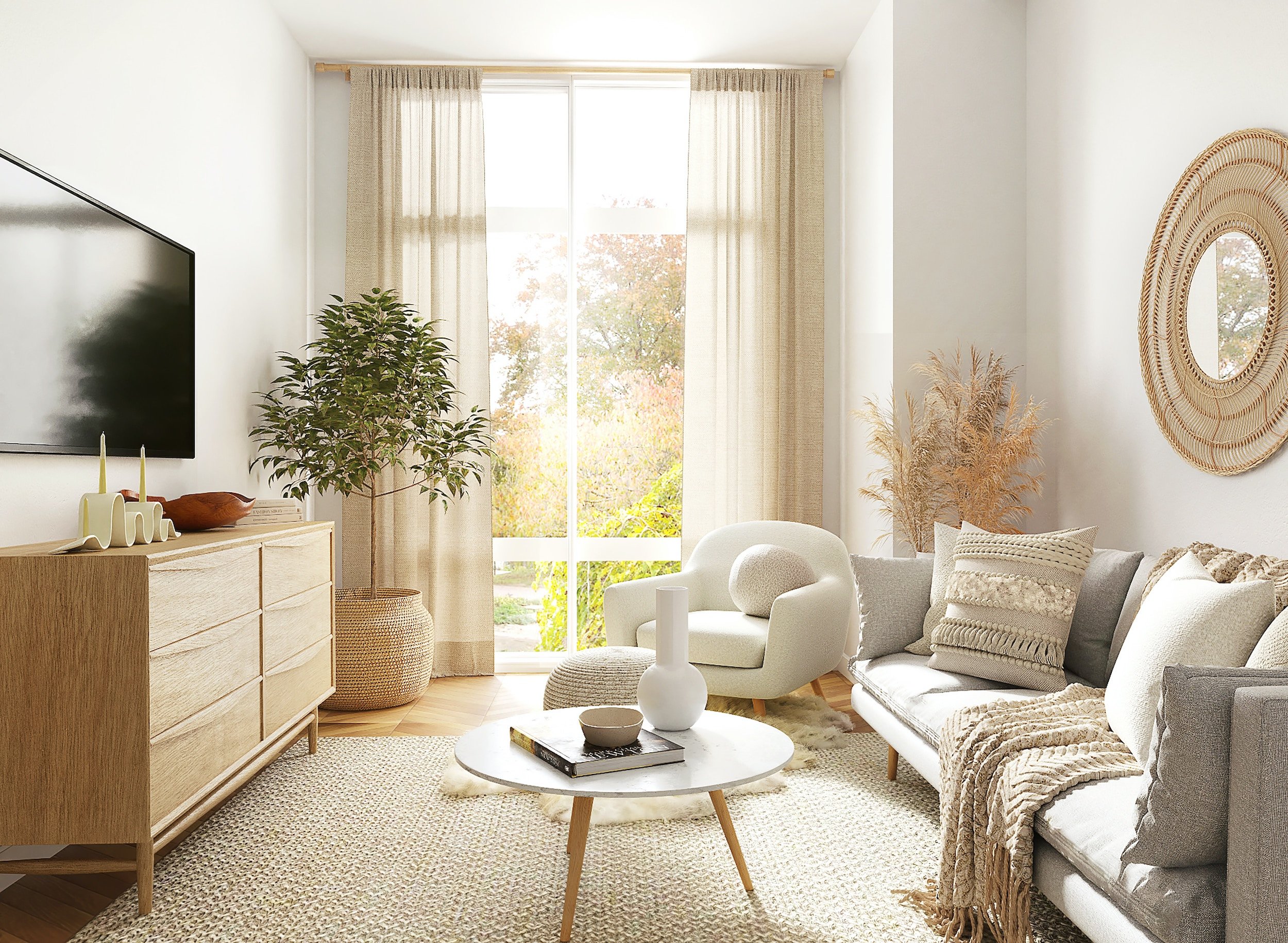 A bright living room with large window and beige curtains, white walls, a wooden sideboard with candles and decor, potted plant, round white coffee table with books and vases, cream and beige armchair and sofa with pillows, Rattan mirror and dried plants, and a beige rug.