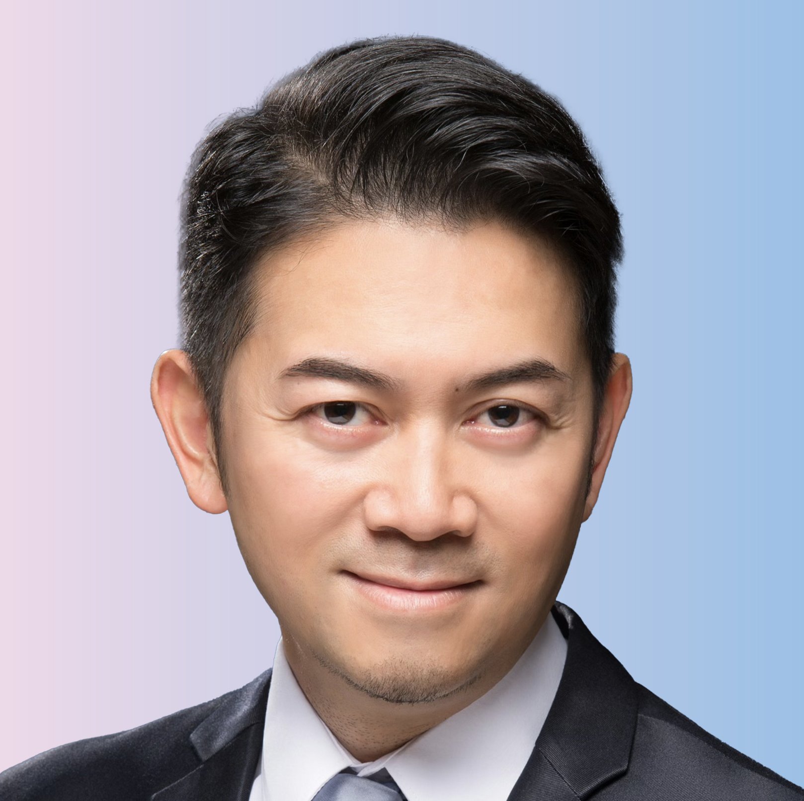 Close-up of a man with dark hair, wearing a black suit and white shirt, against a gradient blue background.