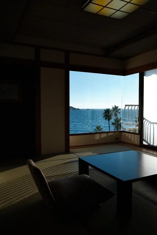 日本の伝統的な旅館の和室の部屋から見える海の景色と木