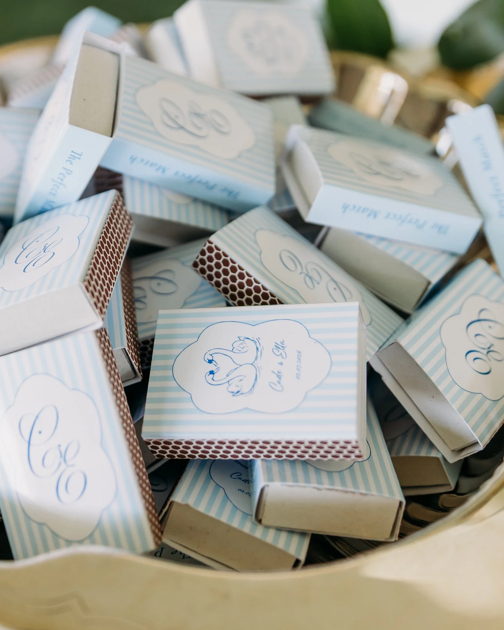 A collection of small, rectangular boxes with light blue and white striped and honeycomb patterns, stacked inside a yellow basket.