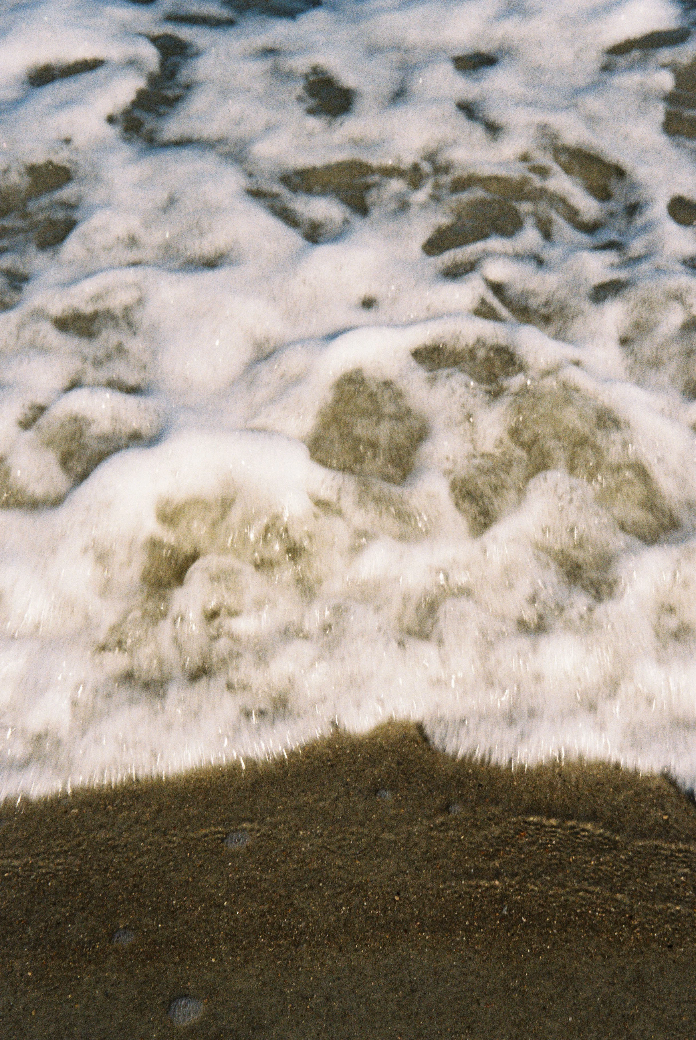 Foamy waves washing onto a sandy beach.
