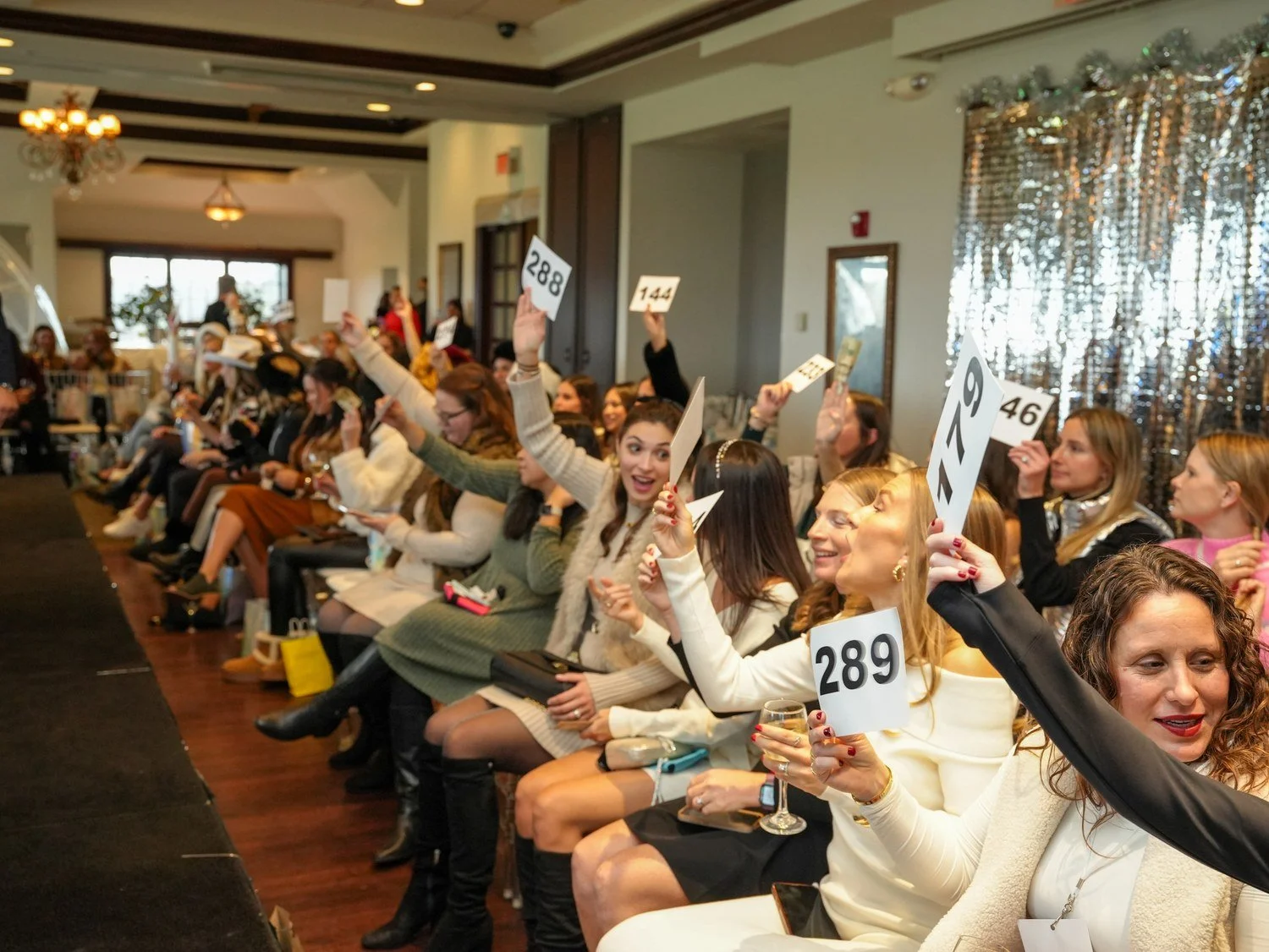 Audience bidding at the Fall Fashion Show