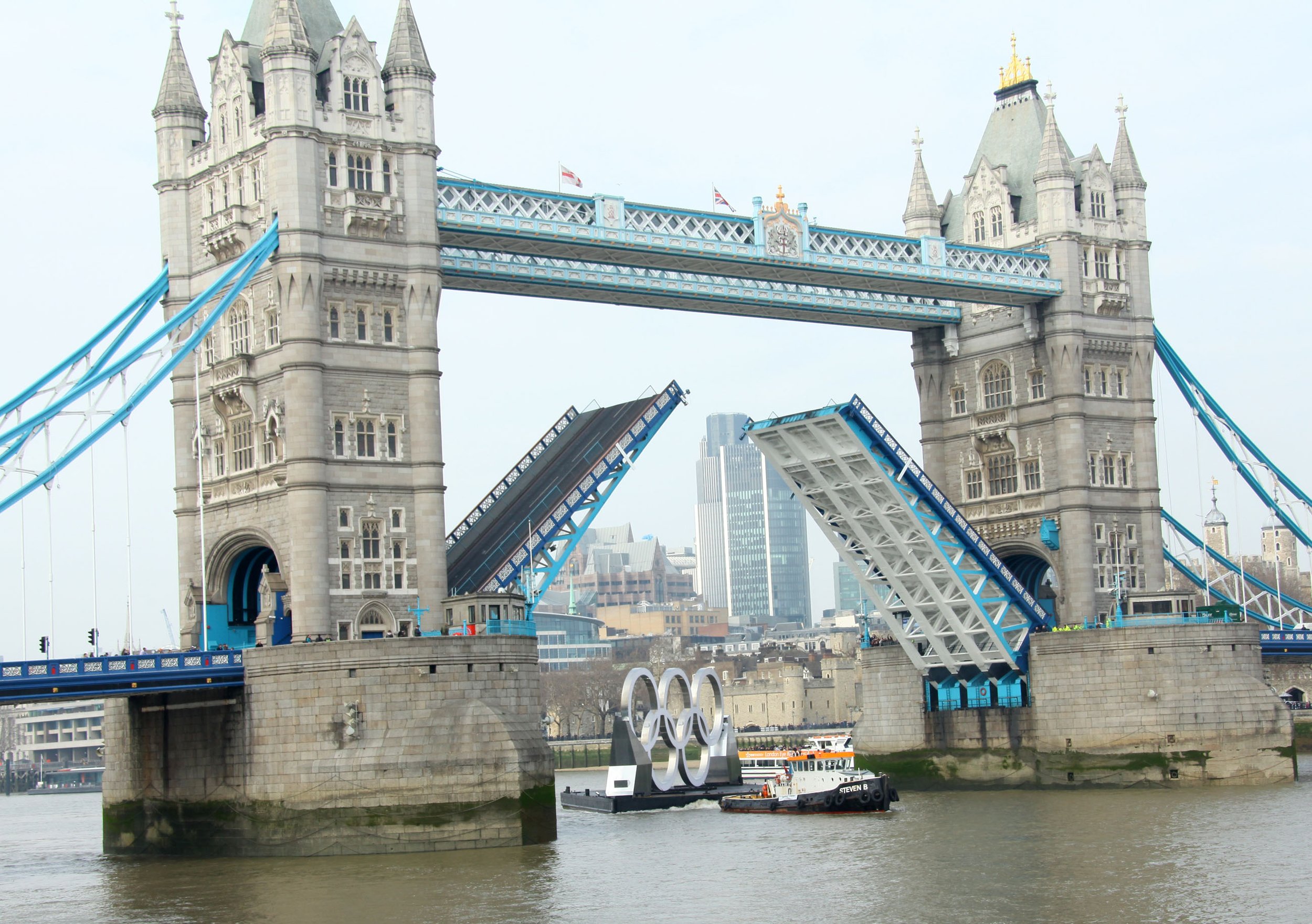 Tower Bridge is raised to pull through the Olympic rings on a barge before the 2012 games in London