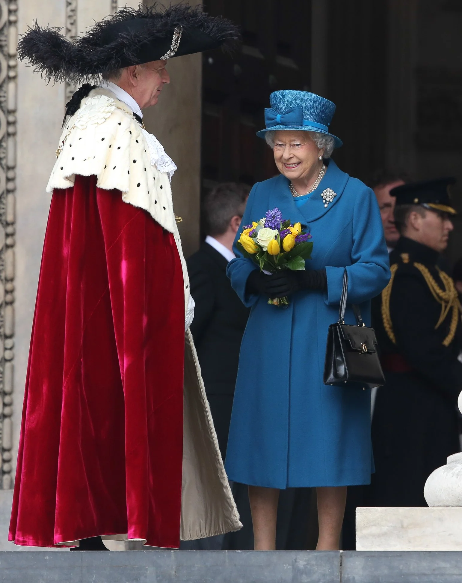 Queen Elizabeth II holding a bouquet of yellow, purple, Lord Mayor of London