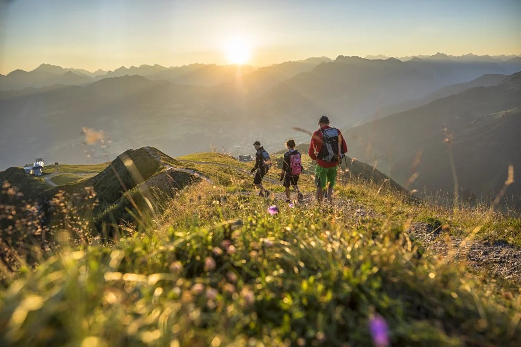 Menschen wandern in den Bergen bei Sonnenuntergang