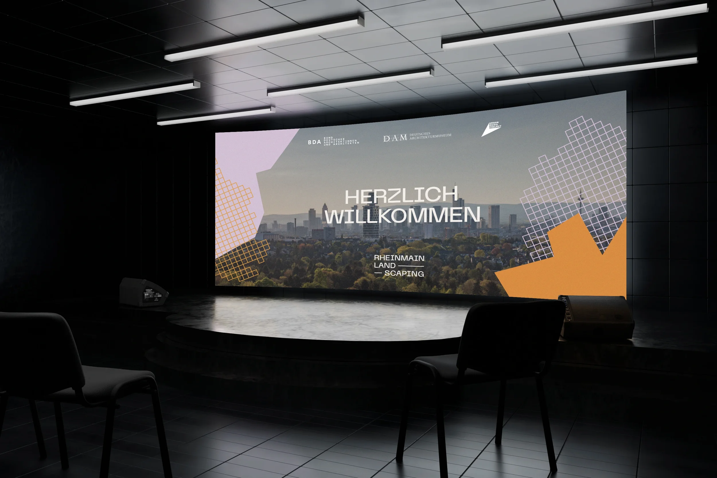 Großer Bildschirm in einem dunklen Raum zeigt eine Stadtansicht und Begrüßung "HERZLICH WILLKOMMEN" mit Logos und Text zu Architektur und Landschaft.