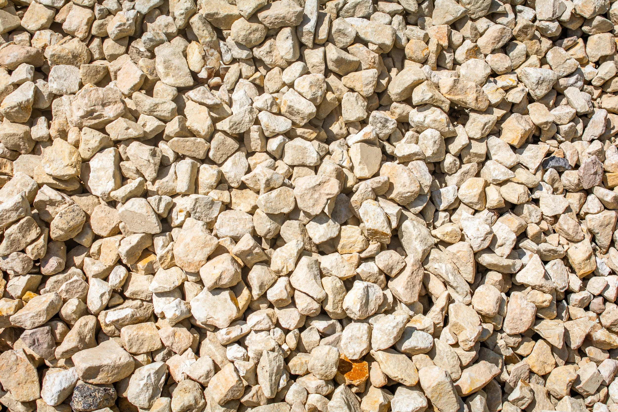 Close-up view of small, irregularly shaped light-colored gravel stones.