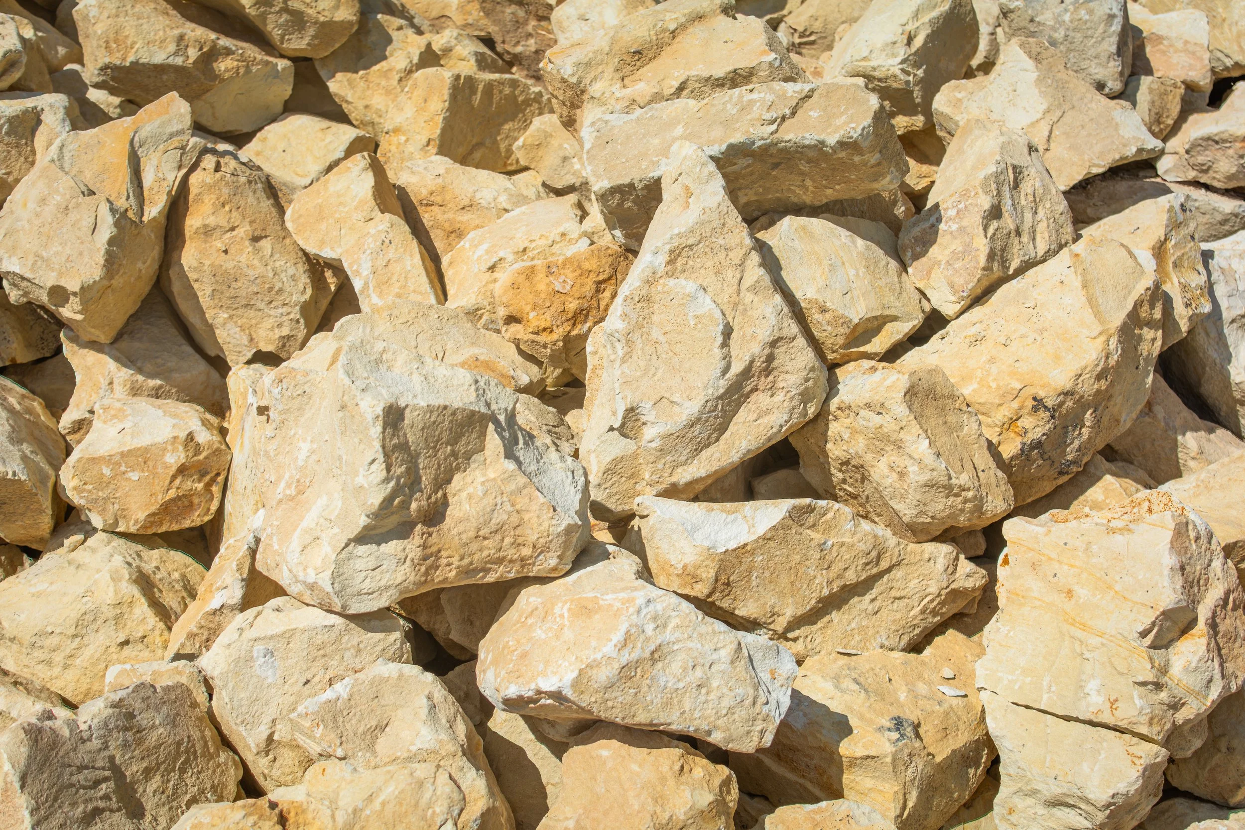 A close-up view of a pile of beige and light brown rocks with rough textures.
