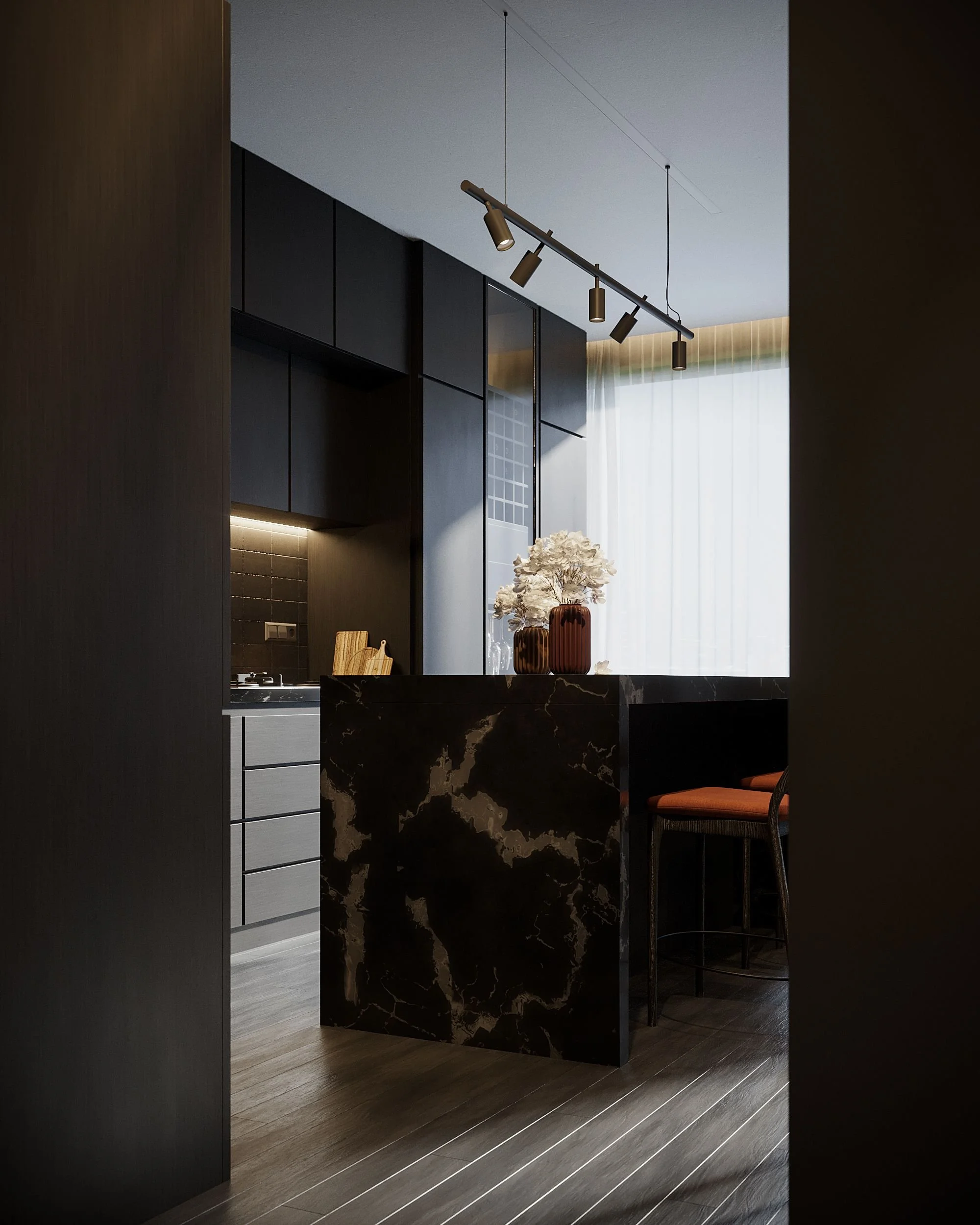 Modern kitchen with black and grey cabinets, marble island with a floral arrangement, and wooden flooring.