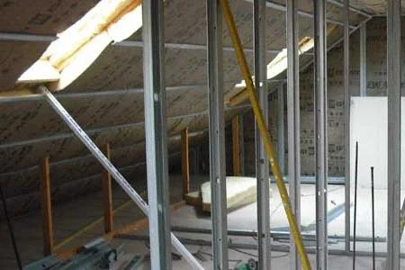Aménagement des combles avec structure en métal et isolant.