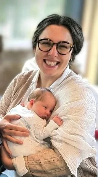 Tash Hallett holding a newborn baby during postnatal support.