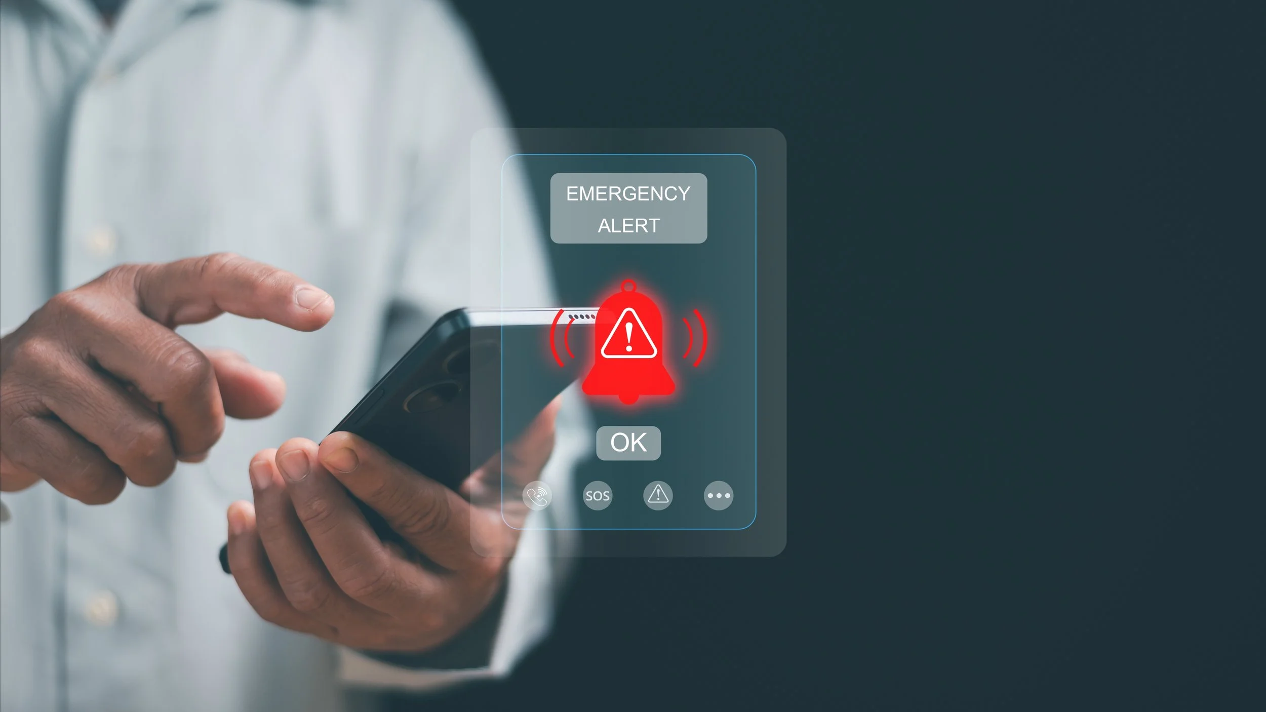 A person in a white shirt holding a smartphone, displaying a holographic emergency alert with a red warning icon and buttons labeled OK, SOS, and other alert symbols.