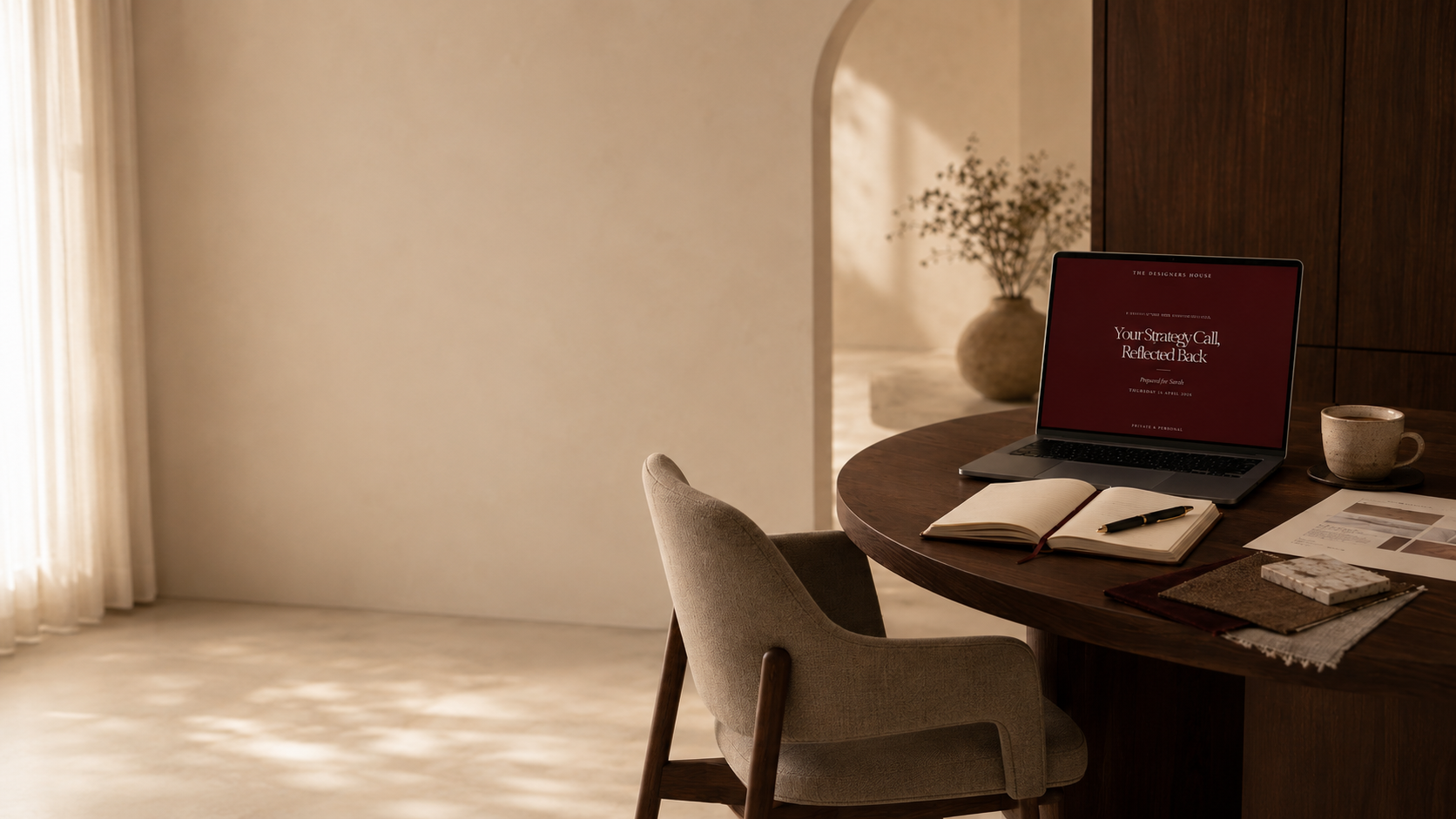 A cozy home workspace with a round wooden table, beige cushioned chair, open notebook, pen, laptop displaying a presentation slide, a coffee mug, and papers. The room has natural light coming through sheer curtains.