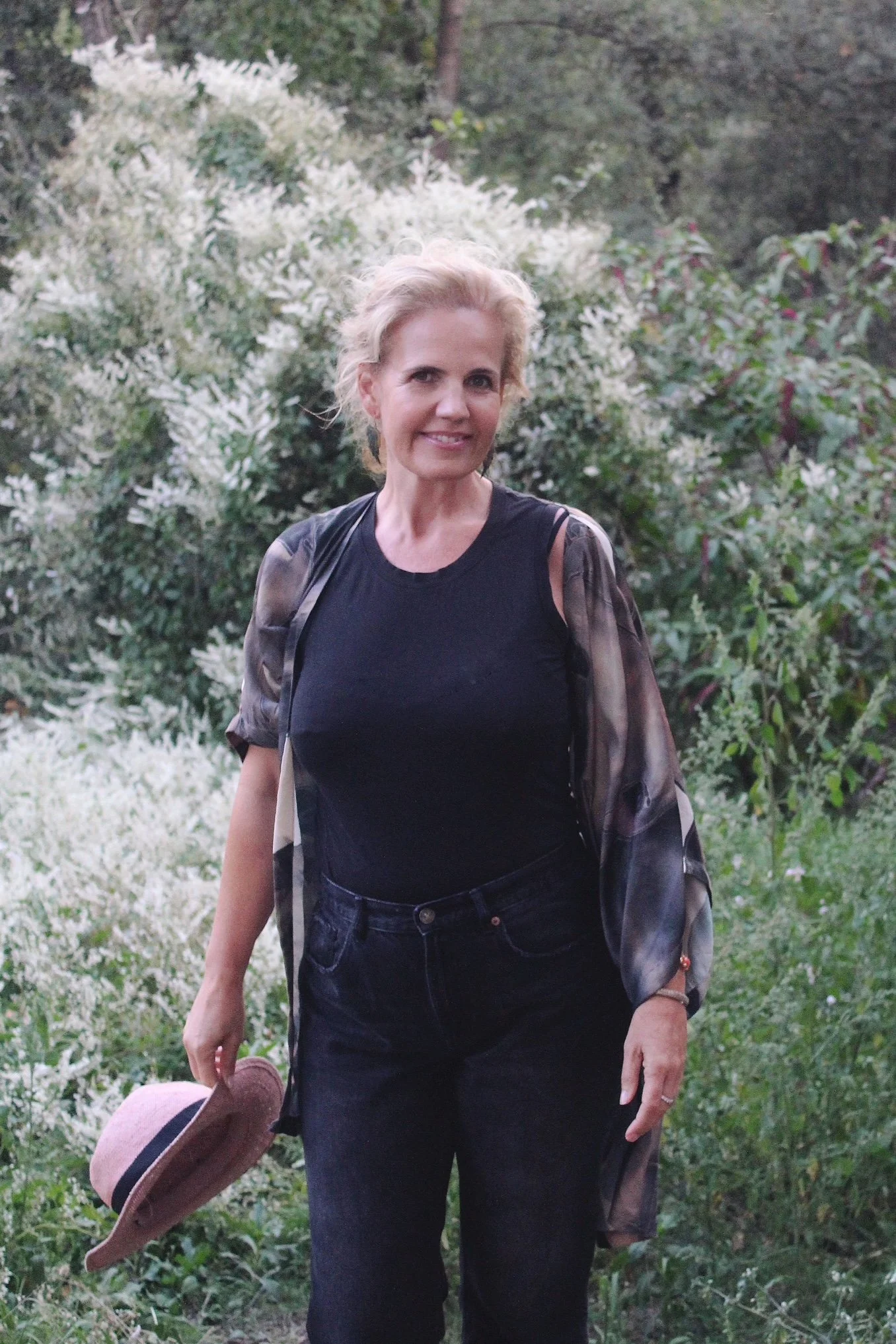 Laura smiling outdoors with greenery behind her, guide of Walk with Laura healing escapes in Miami.