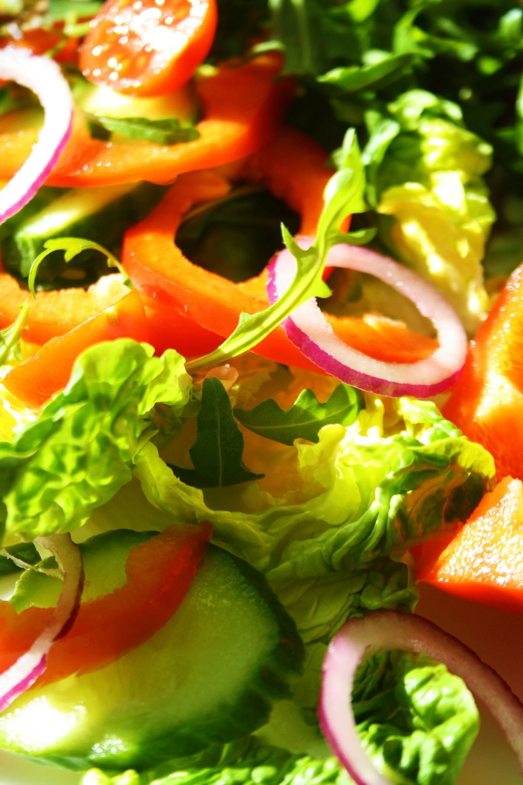 Karışık taze sebze ve yeşillikler, domates, biber, salatalık, kırmızı soğan, marul ve diğer yeşilliklerden oluşan bir salata.