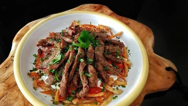 Tabakta kıyma, domates, maydanoz ve baharat ile hazırlanmış yemek.