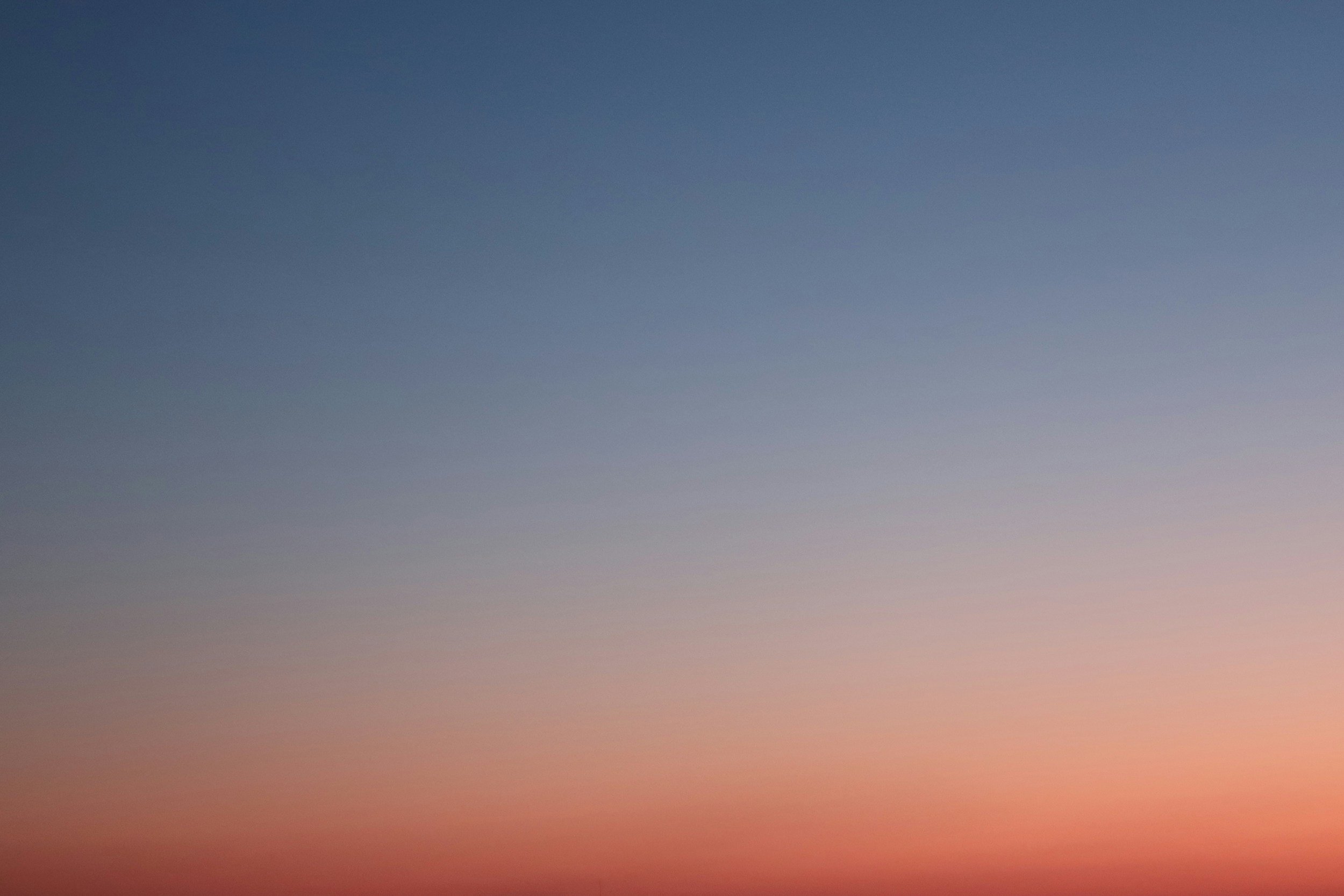 A gradient sky transitioning from deep blue at the top to soft pink near the horizon.