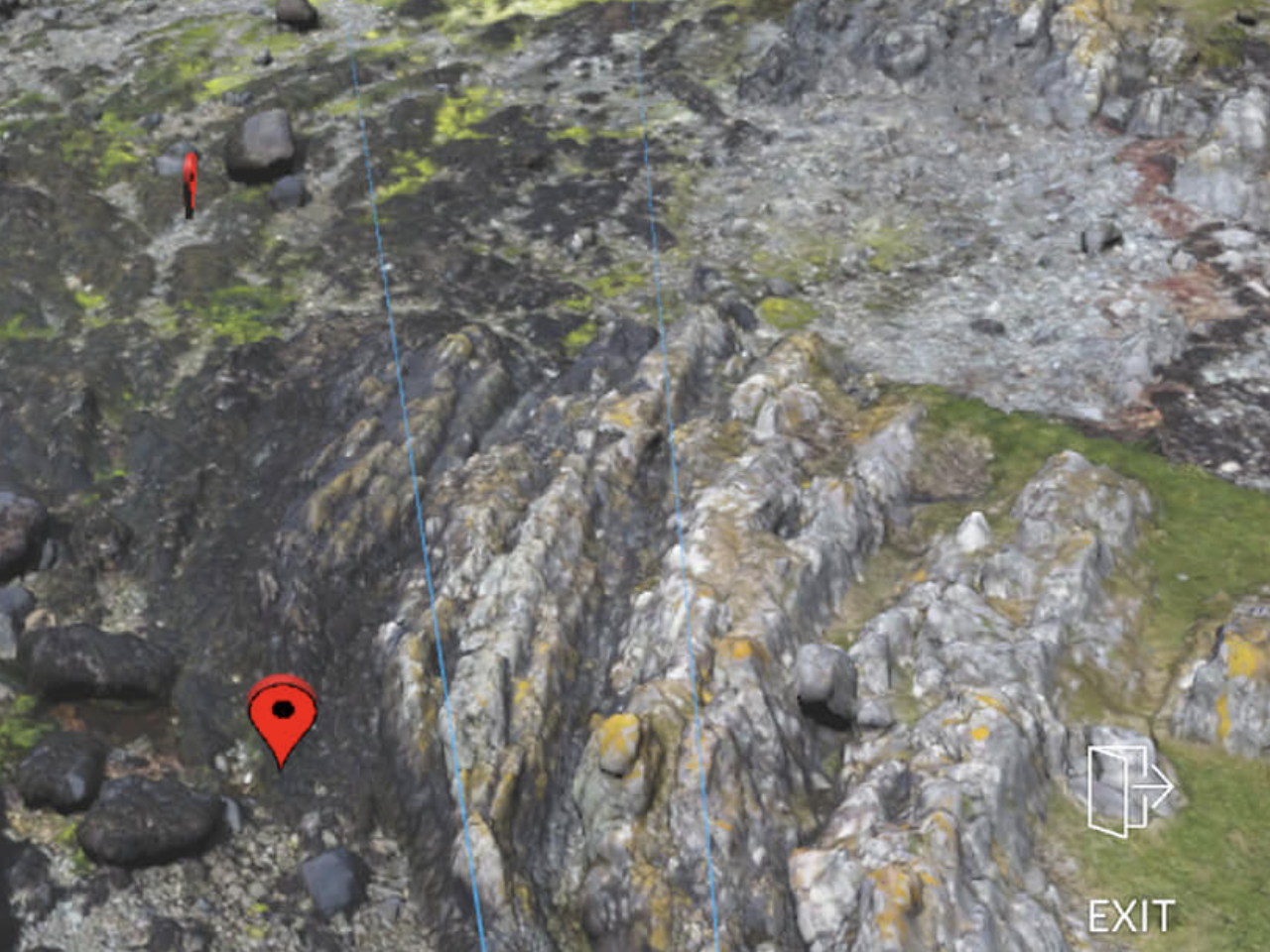 A screenshot from Edify's geology field trip VR app. It shows an aerial view of a photogrammetry scan of the isle of Arran with several red map pins dropped onto it