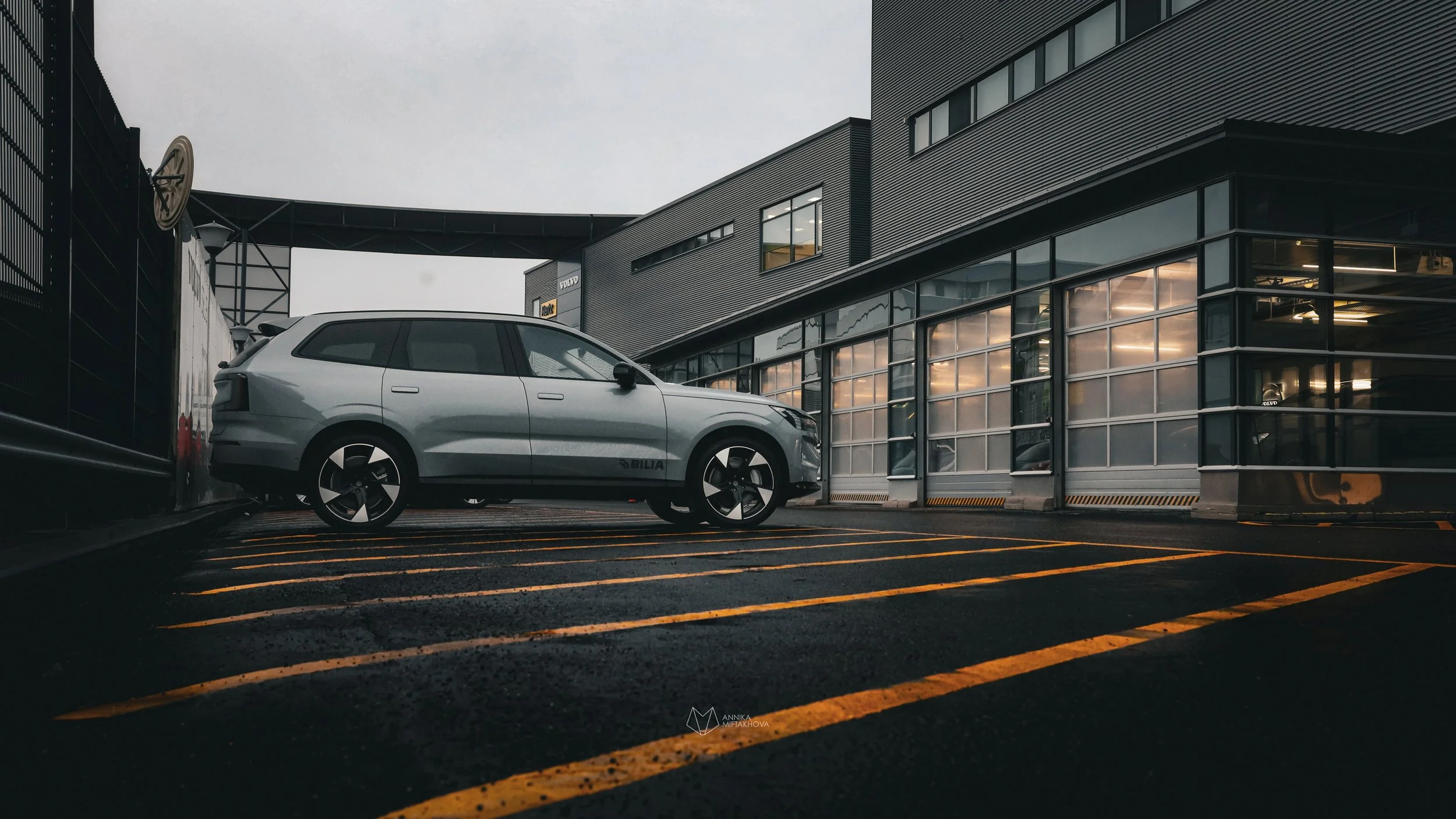 Grey Volvo EX90 photographed in rainy bright yellow parking lot in Helsinki by Annika TheVolvoGirl Miftakhova 