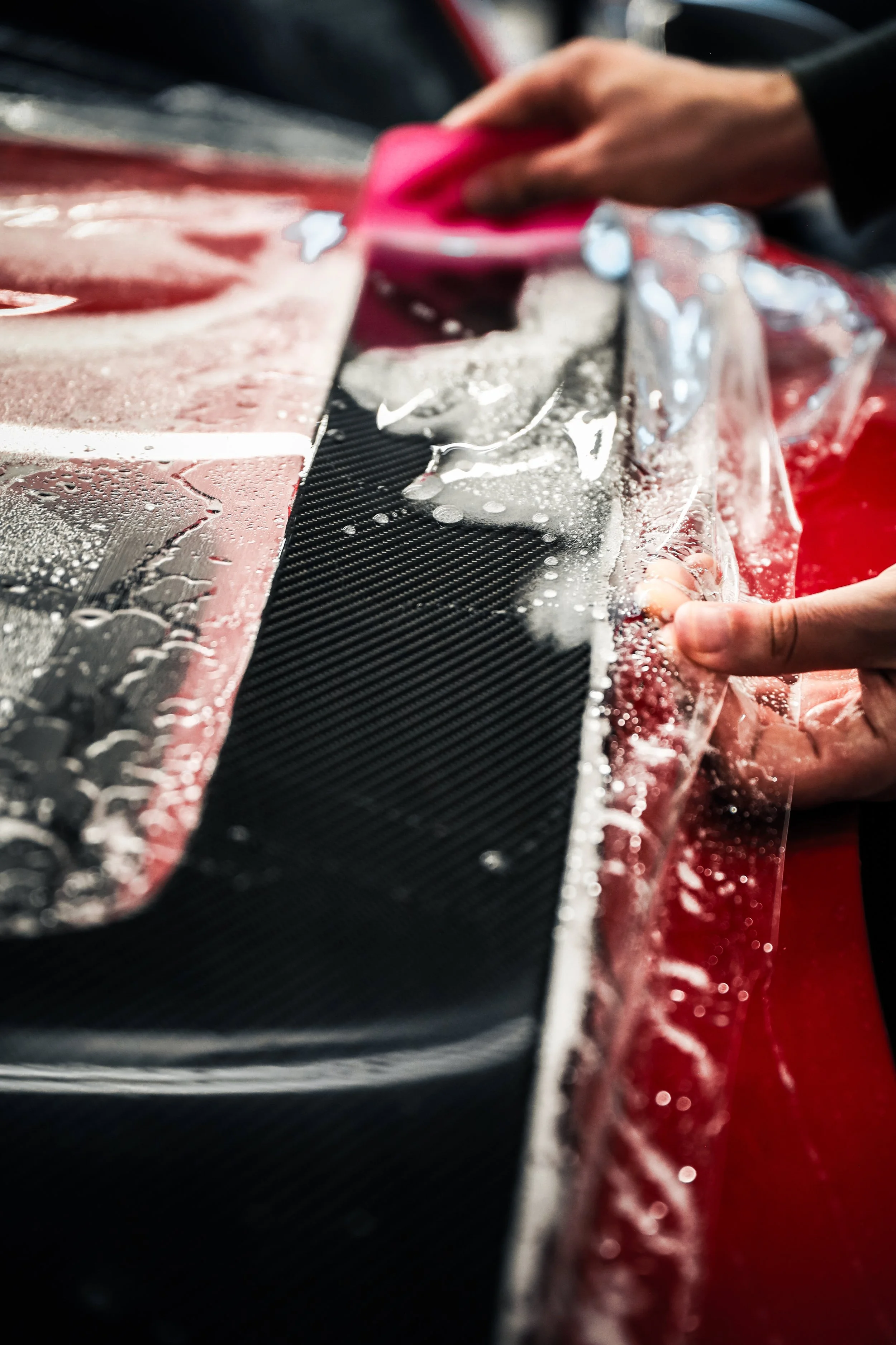 Wrapster workers squeege the liquid out of Paint Protection Film on the Red Porsche GT3 RS in Örebro, Sweden, photographed by Annika TheVolvoGirl Miftakhova.