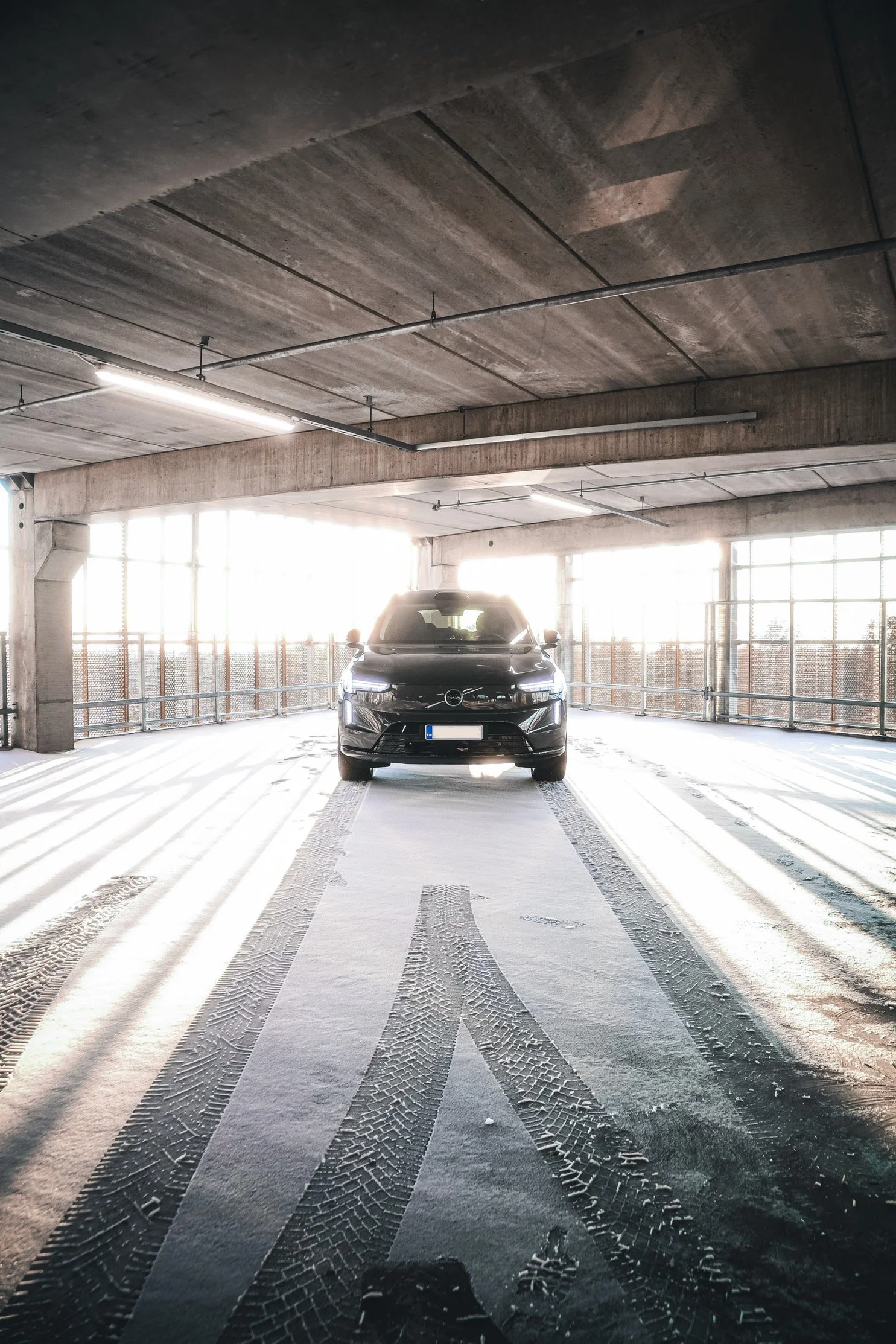 Black Volvo EX90 photographed in winter snow of an open parking lot and baclit by sun in Helsinki by Annika TheVolvoGirl Miftakhova 
