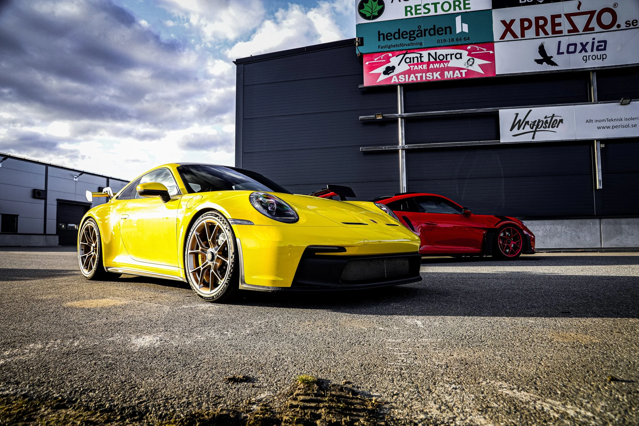 Final result of installed PPF on the Yellow Porsche GT3 and Red Porsche GT3 RS at Wrapster in Örebro, Sweden, photographed by Annika TheVolvoGirl Miftakhova.