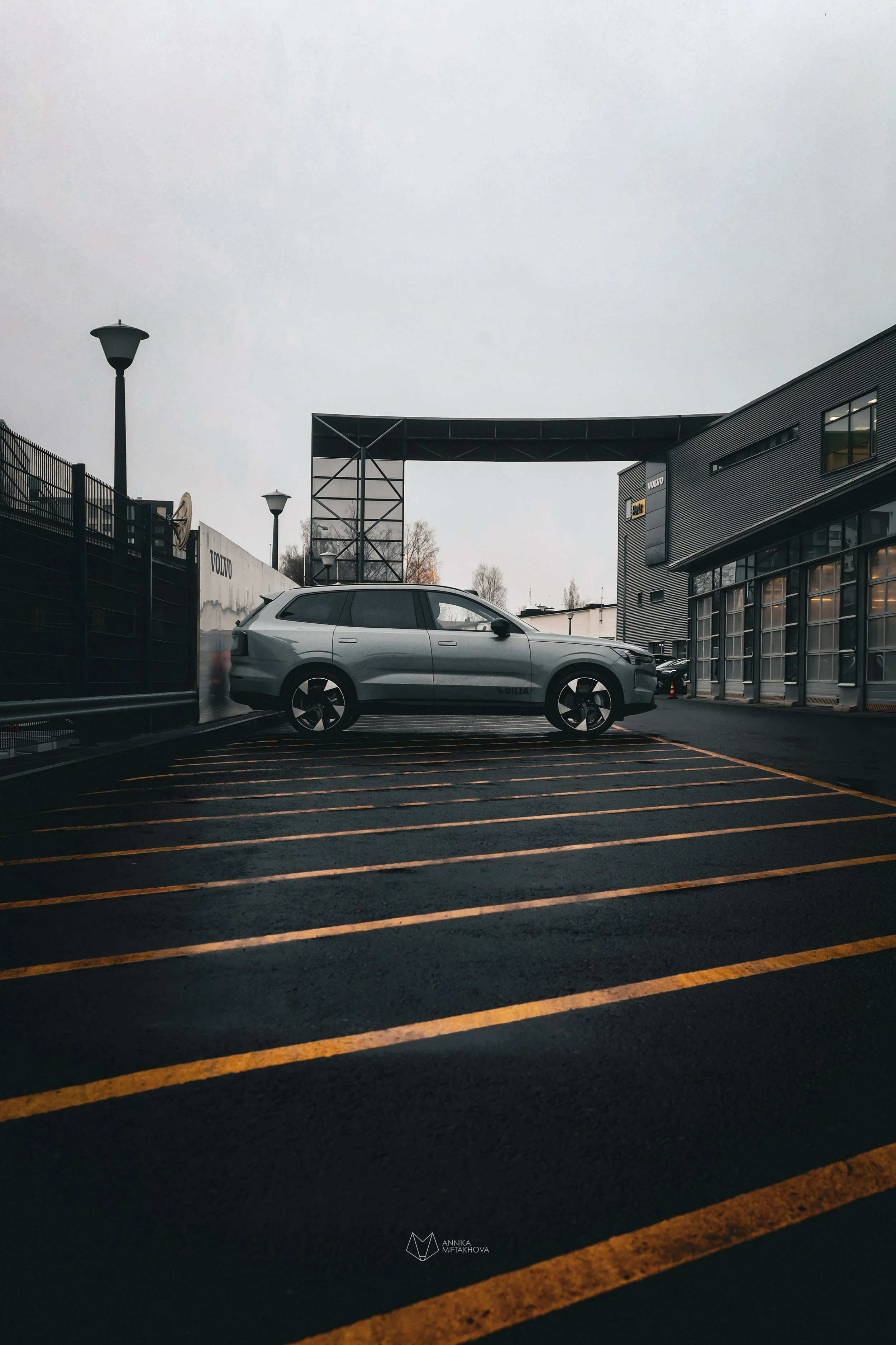 Grey Volvo EX90 photographed in rainy bright yellow parking lot in Helsinki by Annika TheVolvoGirl Miftakhova 