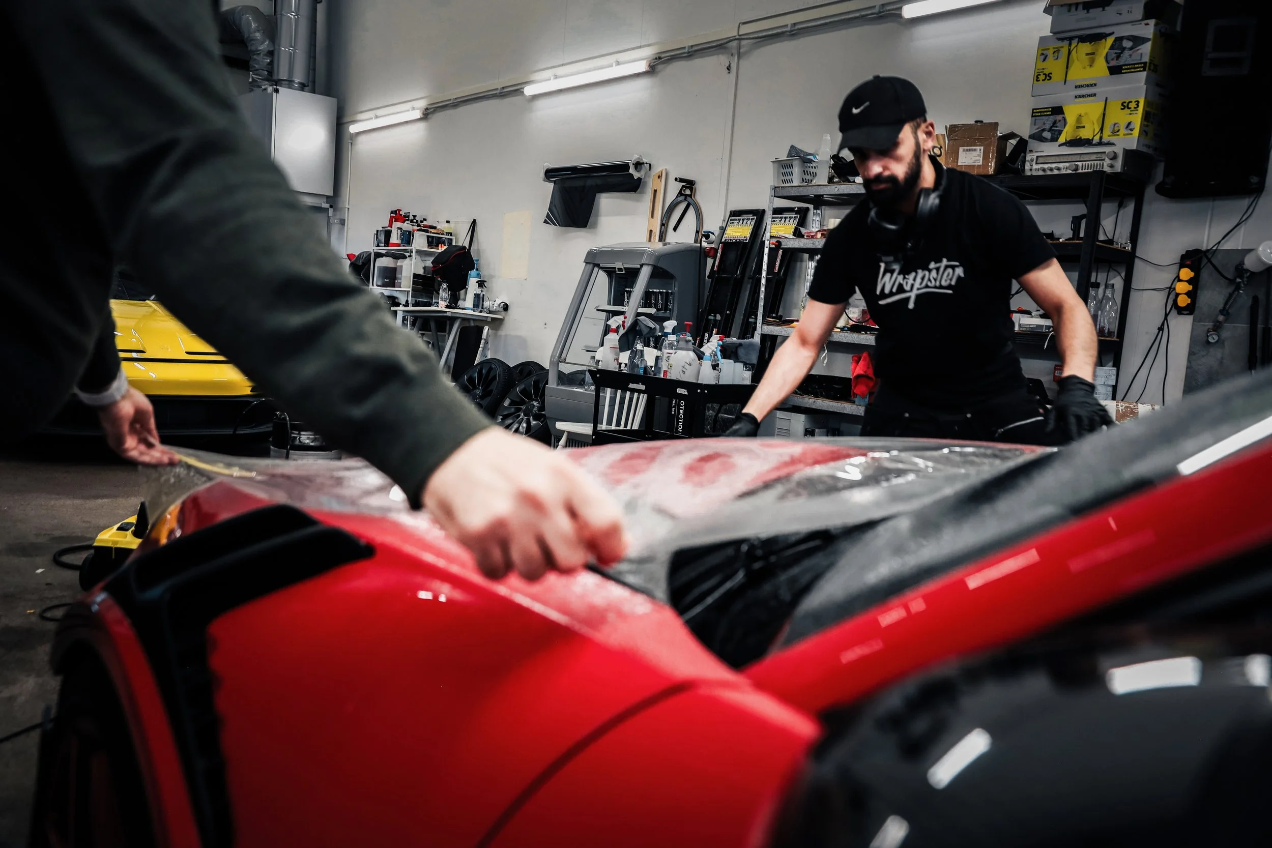 Wrapster workers attach Paint Protection Film to the Red Porsche GT3 RS in Örebro, Sweden, photographed by Annika TheVolvoGirl Miftakhova.