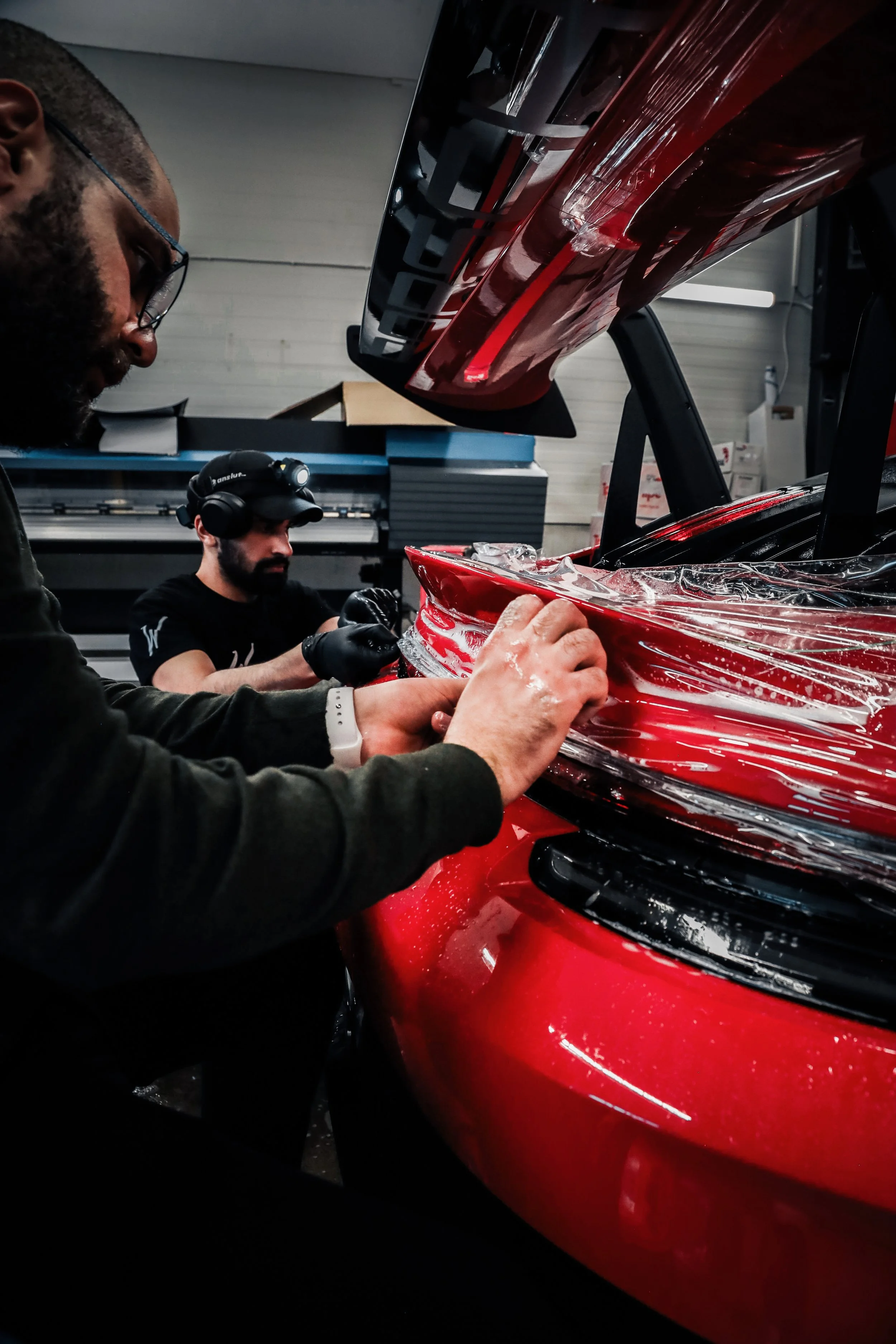 Wrapster workers install Paint Protection Film on the tail of Red Porsche GT3 RS in Örebro, Sweden, photographed by Annika TheVolvoGirl Miftakhova.