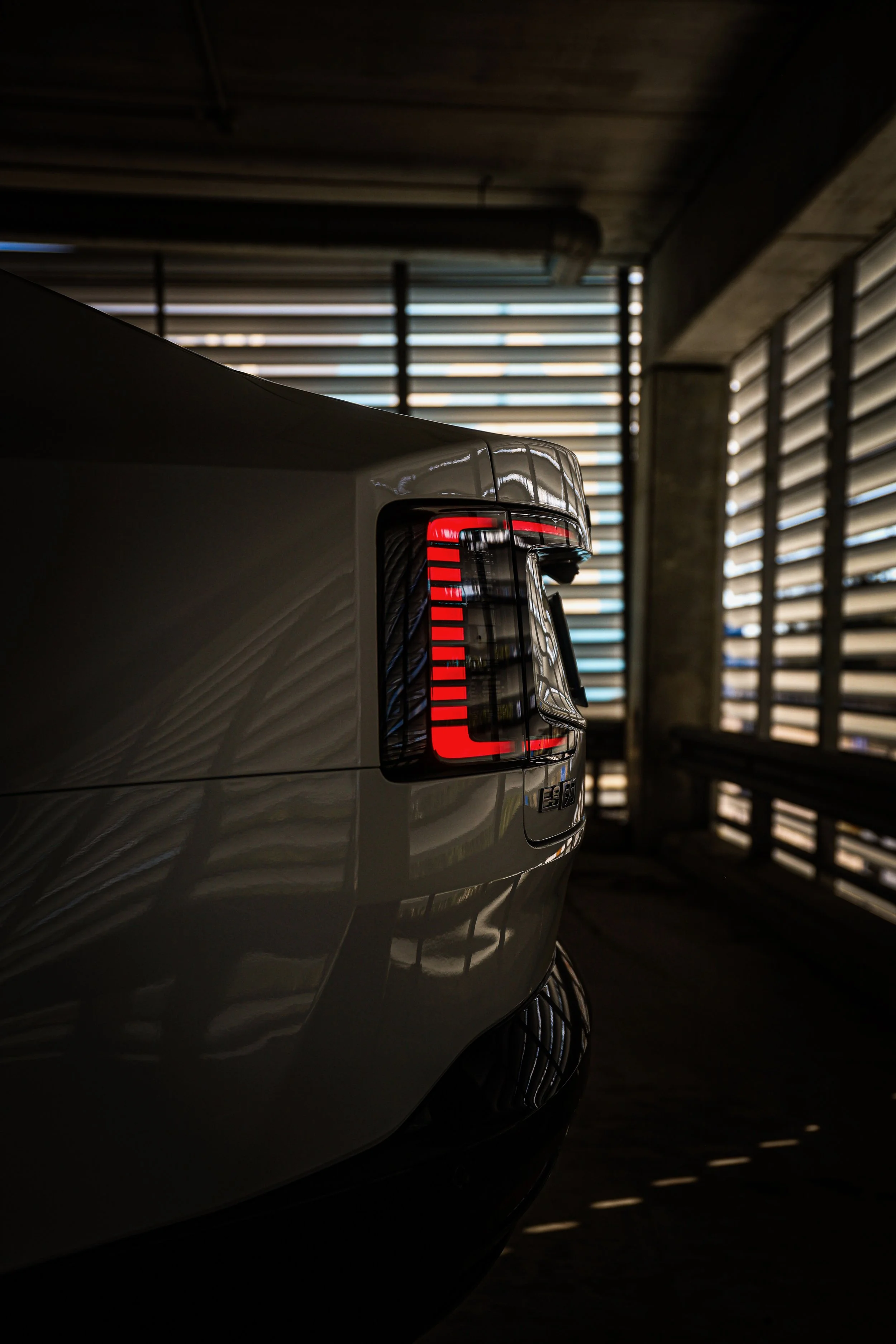 Rear light of White Volvo ES90 photographed in dimmed parking lot in Helsinki, Finland by Annika TheVolvoGirl Miftakhova