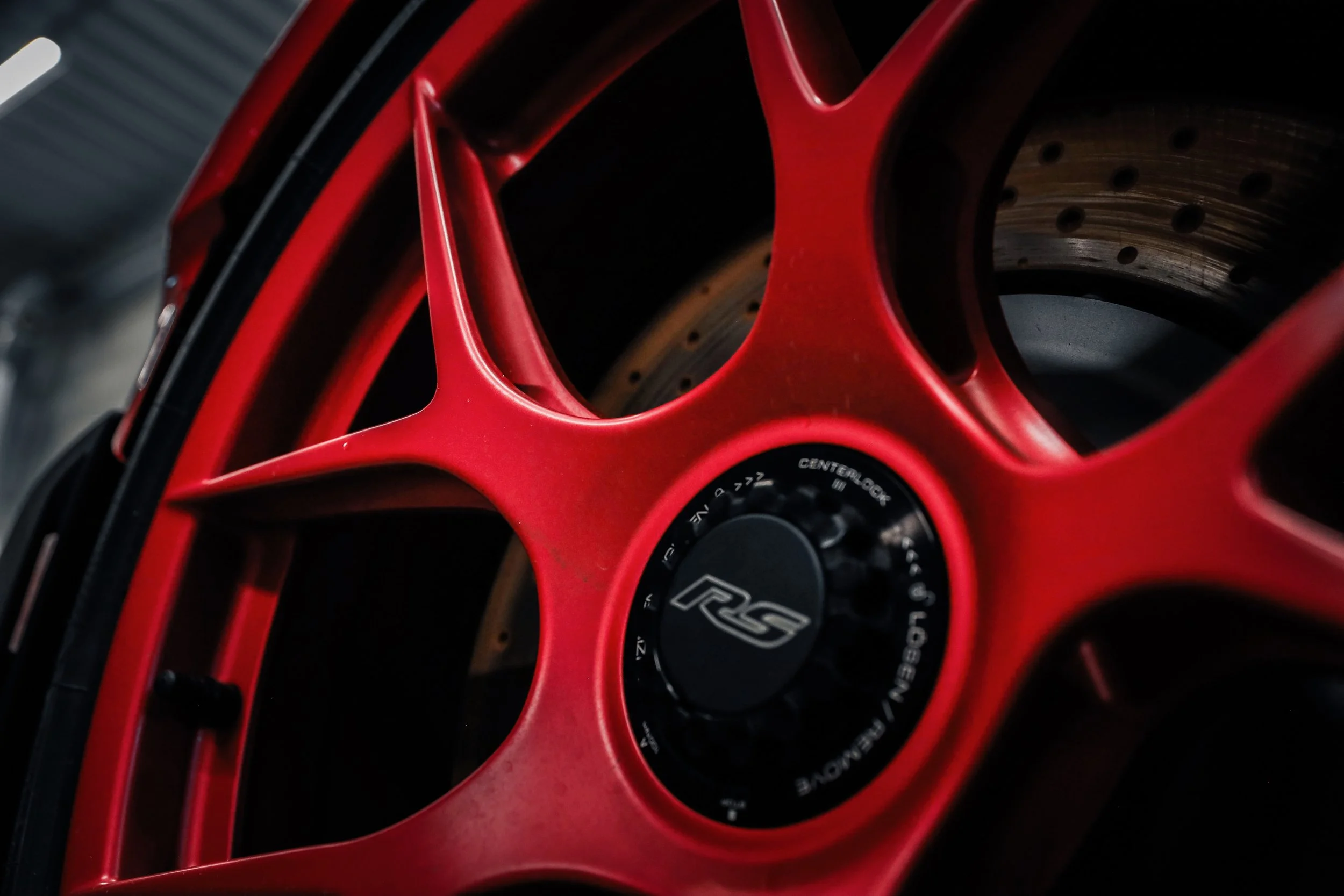 Close-up of the wheel of Red Porsche GT3 RS prepared for Paint Protection Film at Wrapster Sweden in Örebro, Sweden, photographed by Annika TheVolvoGirl Miftakhova.