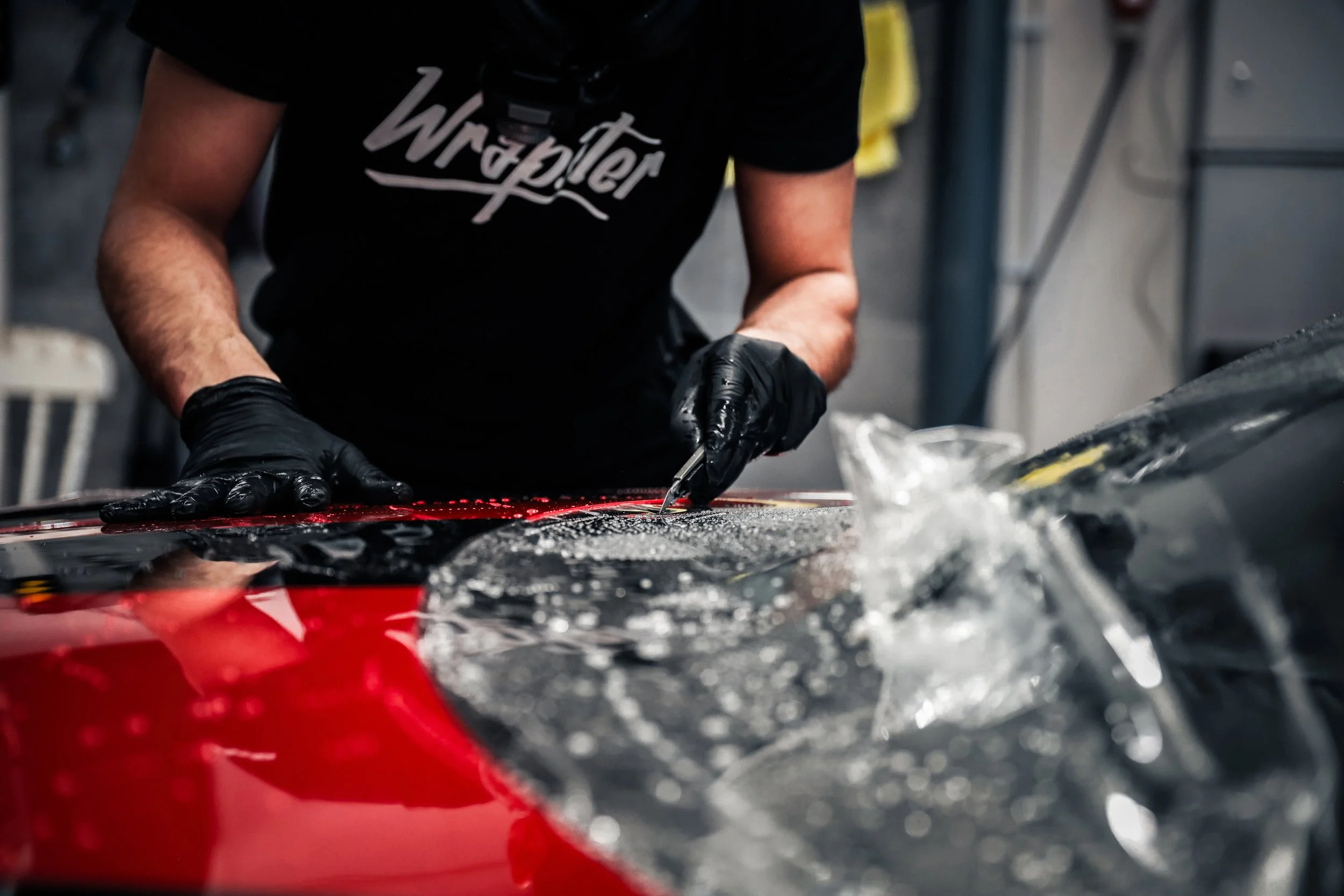 Wrapster workers cut excess Paint Protection Film on the Red Porsche GT3 RS in Örebro, Sweden, photographed by Annika TheVolvoGirl Miftakhova.