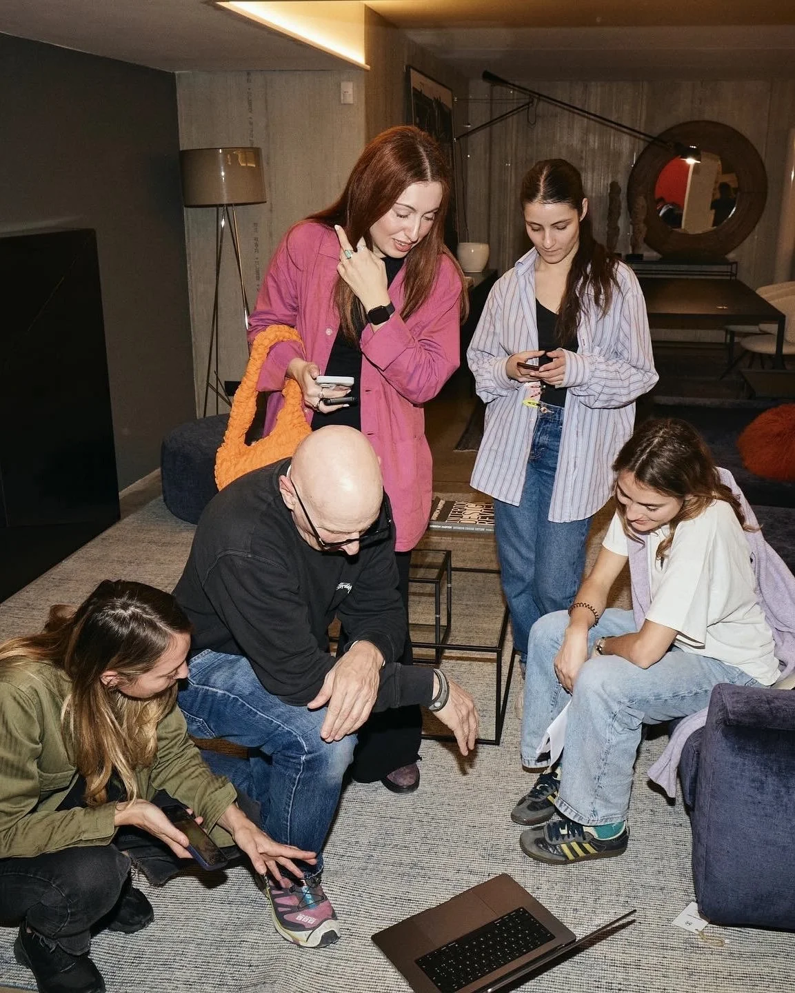 Gruppo di persone che interagiscono in una sala moderna, durante lo svolgimento di uno shooting fashion in location.